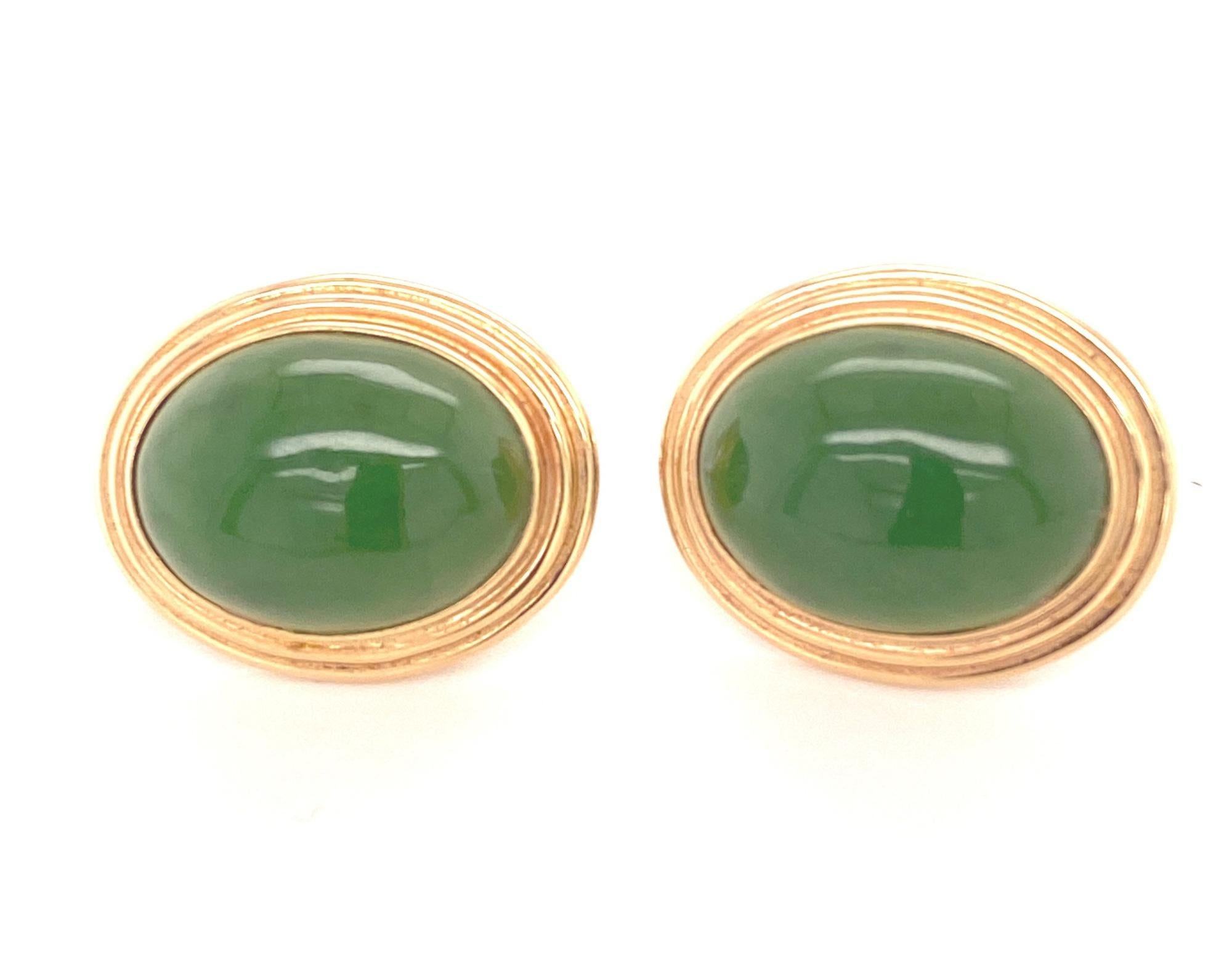 This is a stunning pair of natural jade earrings by Gump's. The earrings have oval shaped cabochons that have a nice green color and they are translucent. The earrings are marked Gump's 14K. They are in excellent condition. Measure 20.5mm high by