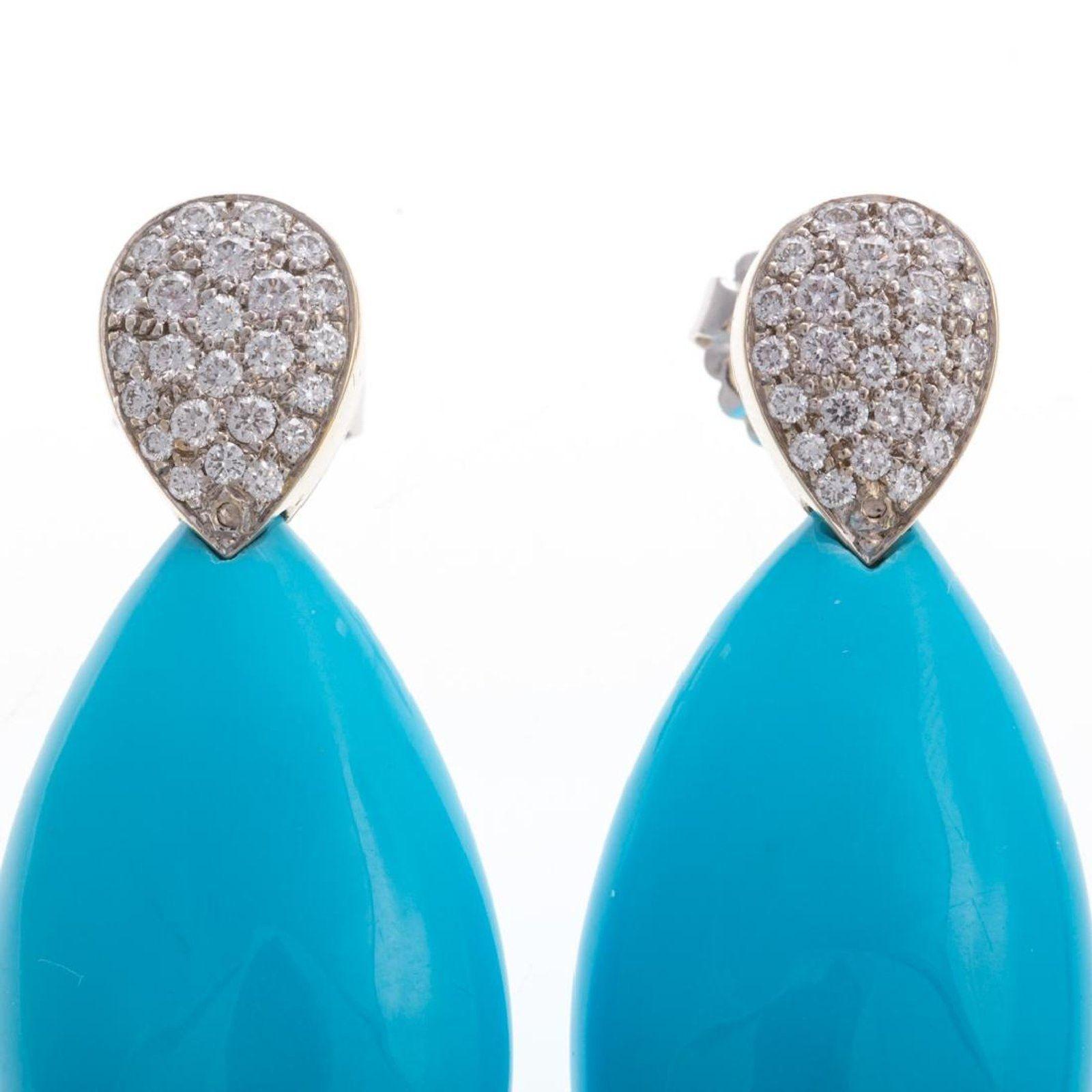 18K white gold earrings by Gump's featuring 2 well matched pear shape sleeping beauty Persian turquoise measuring 20 mm x 37 mm at the bottom of the earrings. Adorned with full cut diamonds weighing 1.18 carat, pave set in a pear shape at the top of
