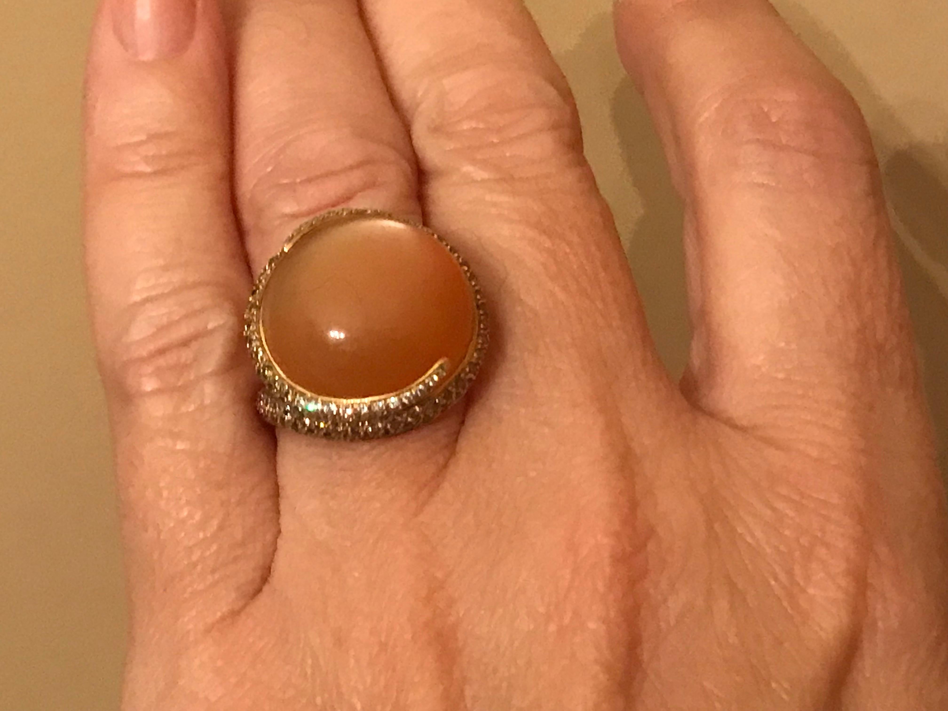 18K ring with round moonstone cabochon surrounded by diamonds ranging in color from cognac to white.
Size 6. Can be sized.