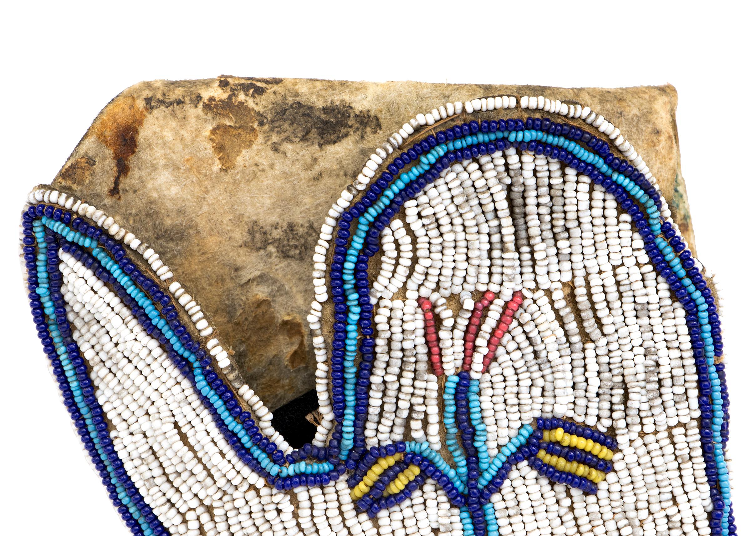 This beaded Sioux gun holster, dating from circa 1890, is a stunning example of 19th-century Native American beadwork from the Plains Indians. The holster is intricately decorated with glass trade beads on one side, featuring a stylized corn plant