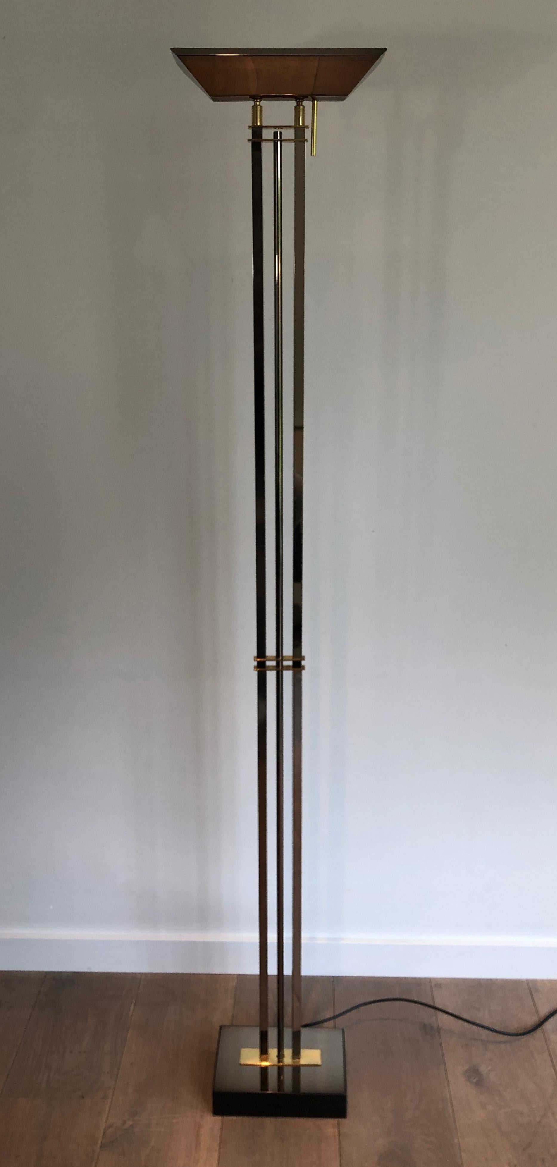 This floor lamp is made of gun metal and brass. This is a French work. Circa 1970