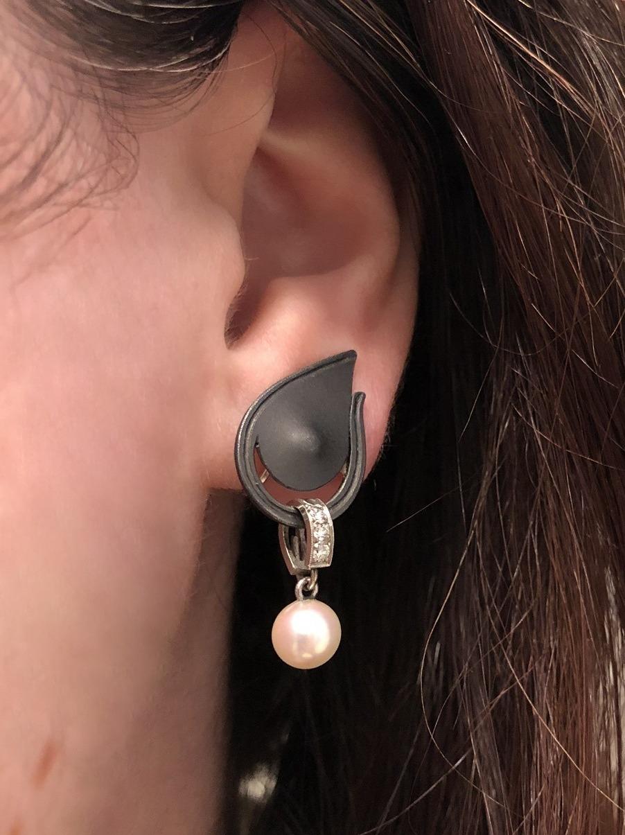 Gunmetal paisley motifs suspend cultured pearls from diamond links containing a total of 0.15 carat of round diamonds.  Length approximately 1-1/4 inches, width approximately 3/4 inch.
