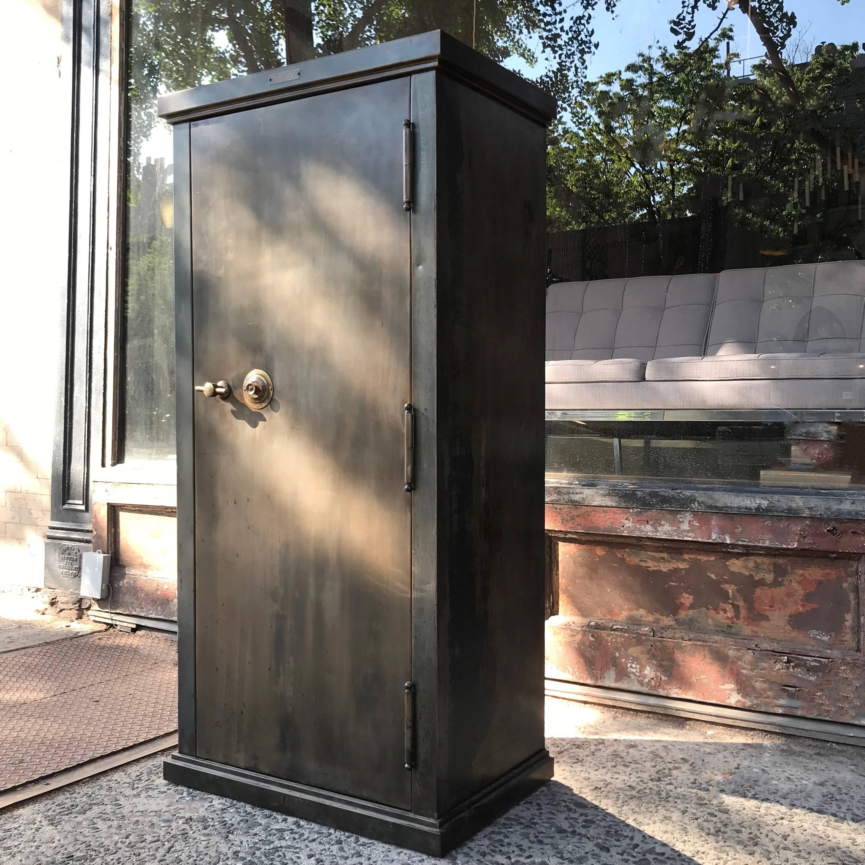 Stately, early 20th century, safe cabinet by The Safe Cabinet Co, Marietta OH features a newly finished, gunmetal steel exterior with brass handle and combination lock and original paint interior with adjustable shelves.