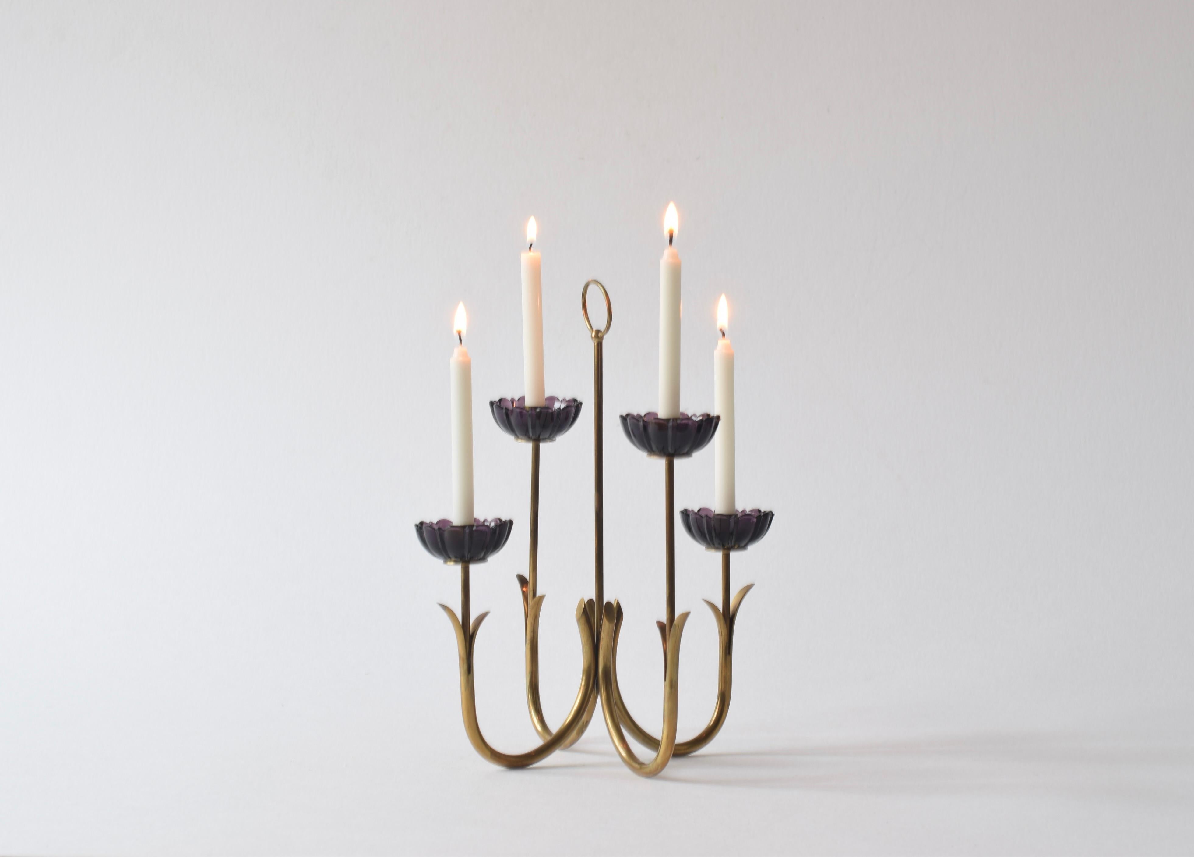 Four arm candelabra by Swedish designer Gunnar Ander (1908-1976) for Ystad Metall, Sweden. Made ca 1960s.

The candelabra is made from brass and shaped as four stylized flowers with blossoms of purple glass. 

It holds slim sized tapers.

The