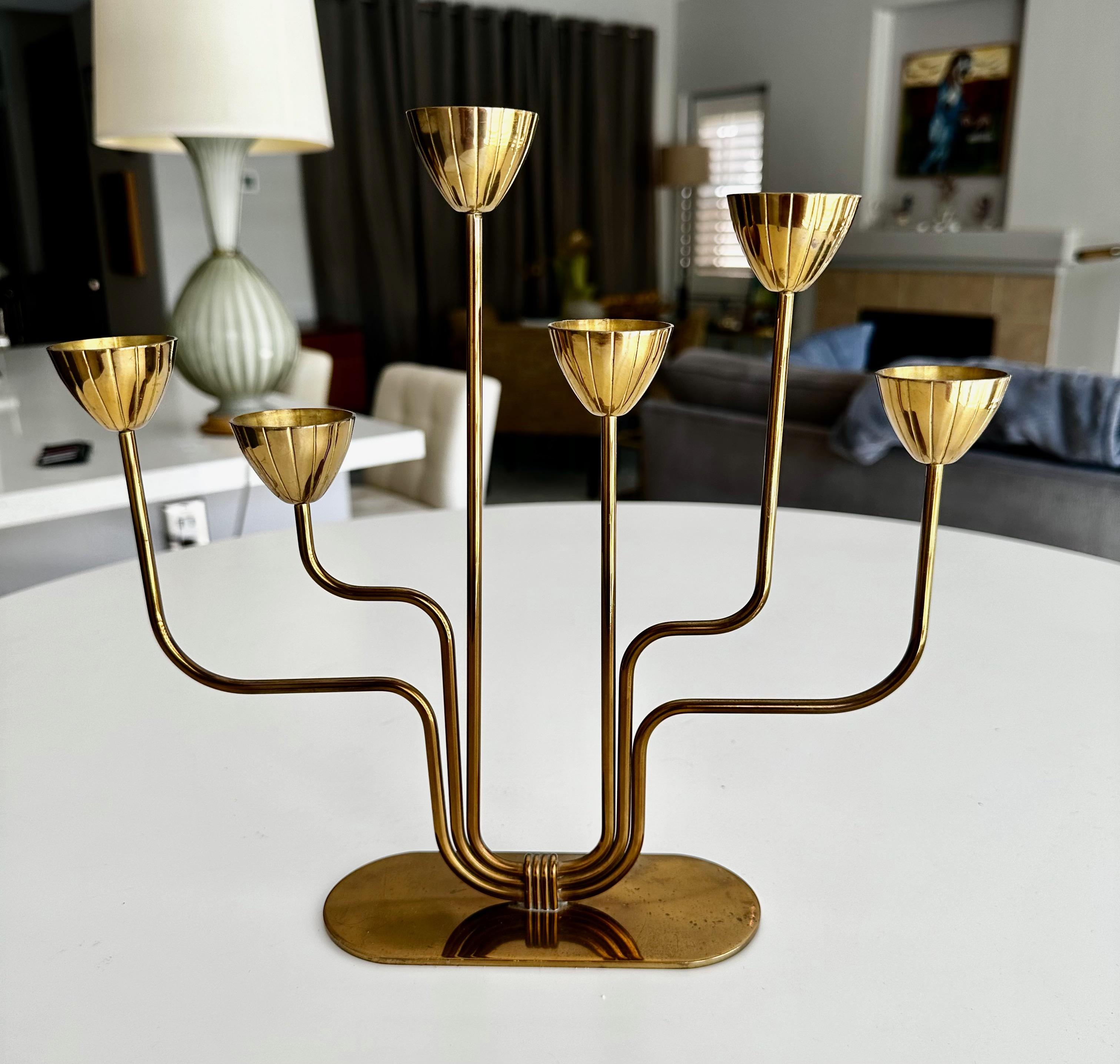 Single 6 arm brass candlestick designed by Gunnar Ander. Produced by Ystad Metall in Sweden.