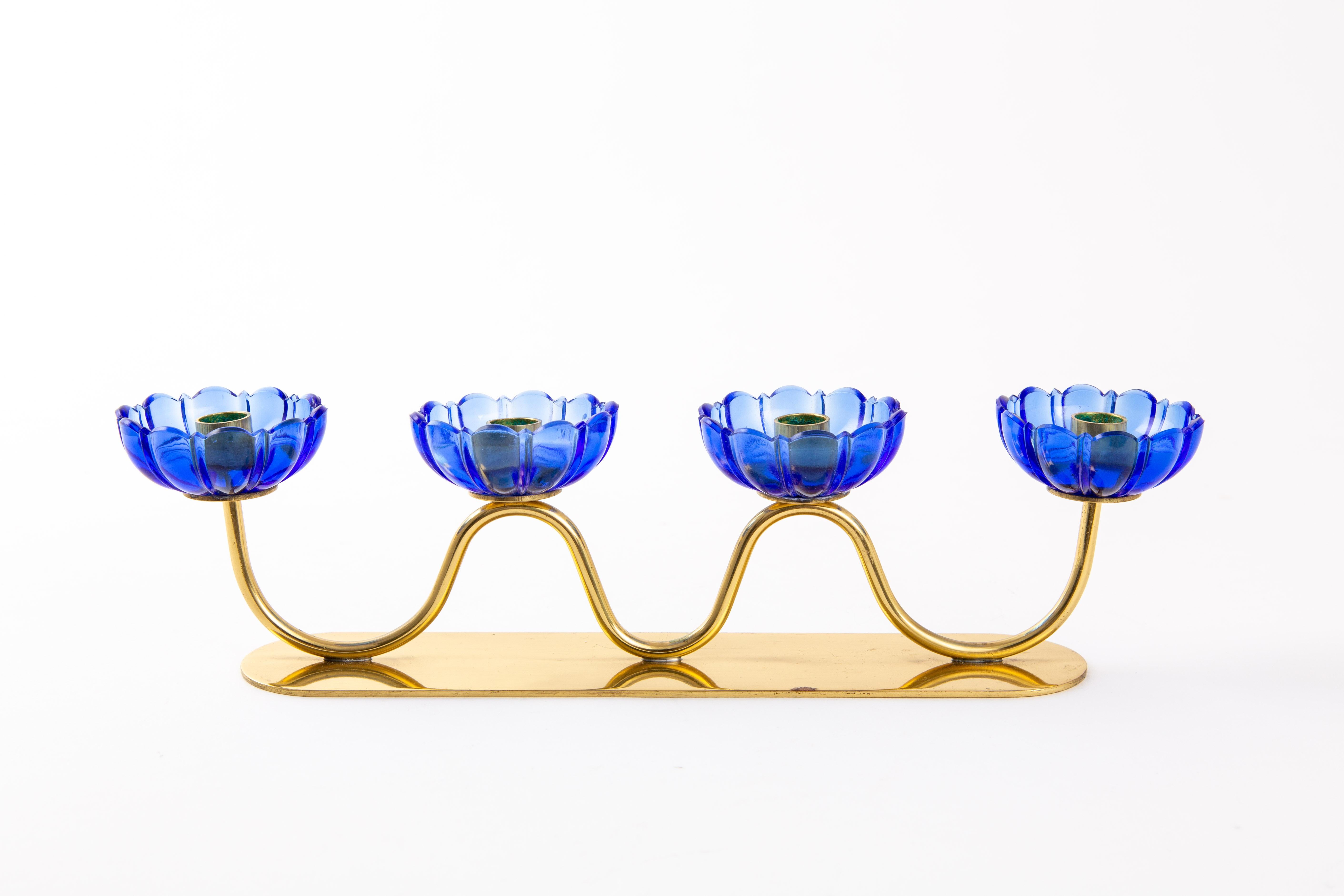 Gunnar Ander candleholder. A candleholder with blue transparent art glass. Designed by Gunnar Ander for Swedish Ystad-Metall. The candelabra marked on the bottom.