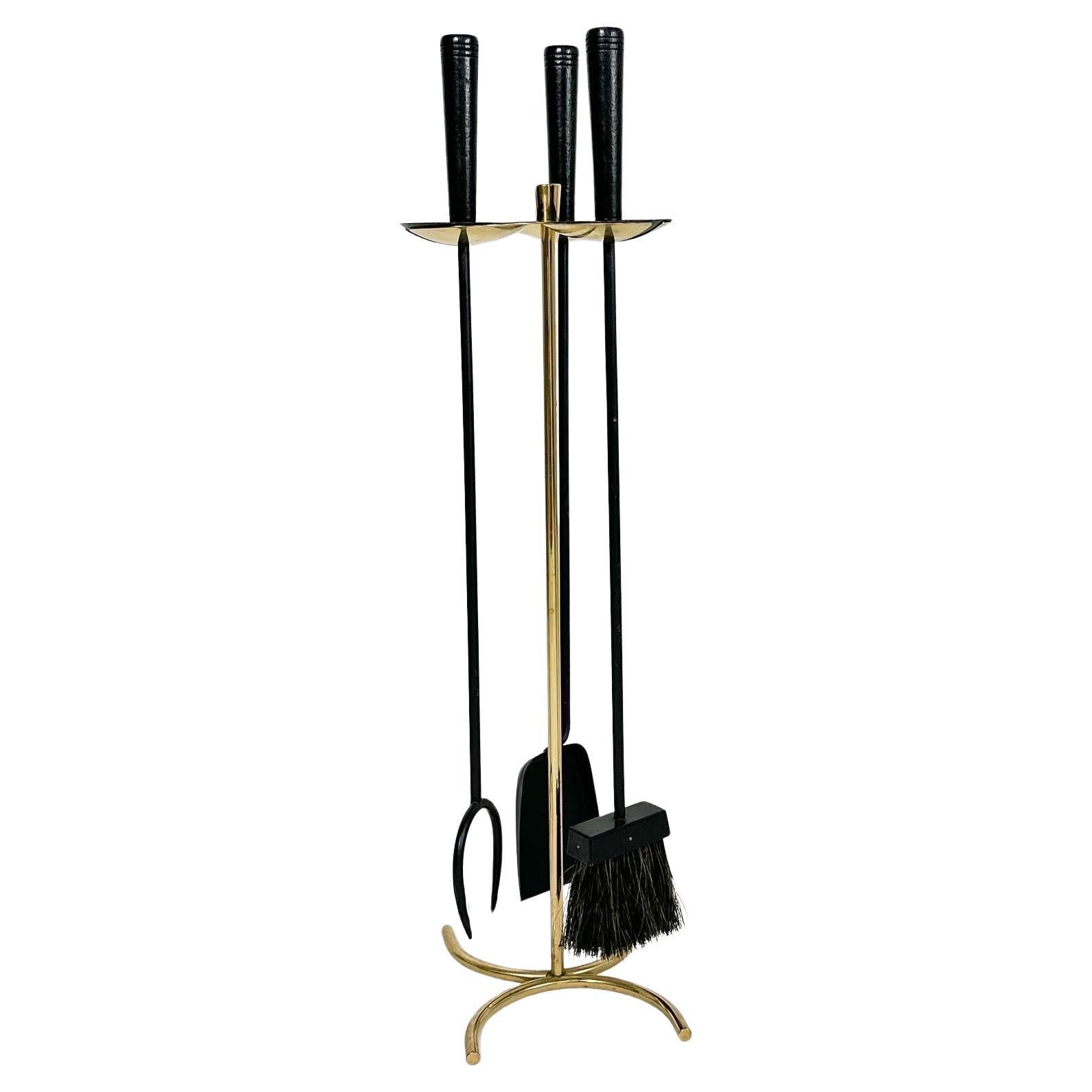 Utensilios para chimenea Gunnar Ander de acero lacado en negro, latón, un cepillo de pelo de caballo y mangos de madera, fabricados por Ystad-Metall en Suecia en la década de 1960
 
Las partes de latón se han pulido ligeramente, la laca negra está