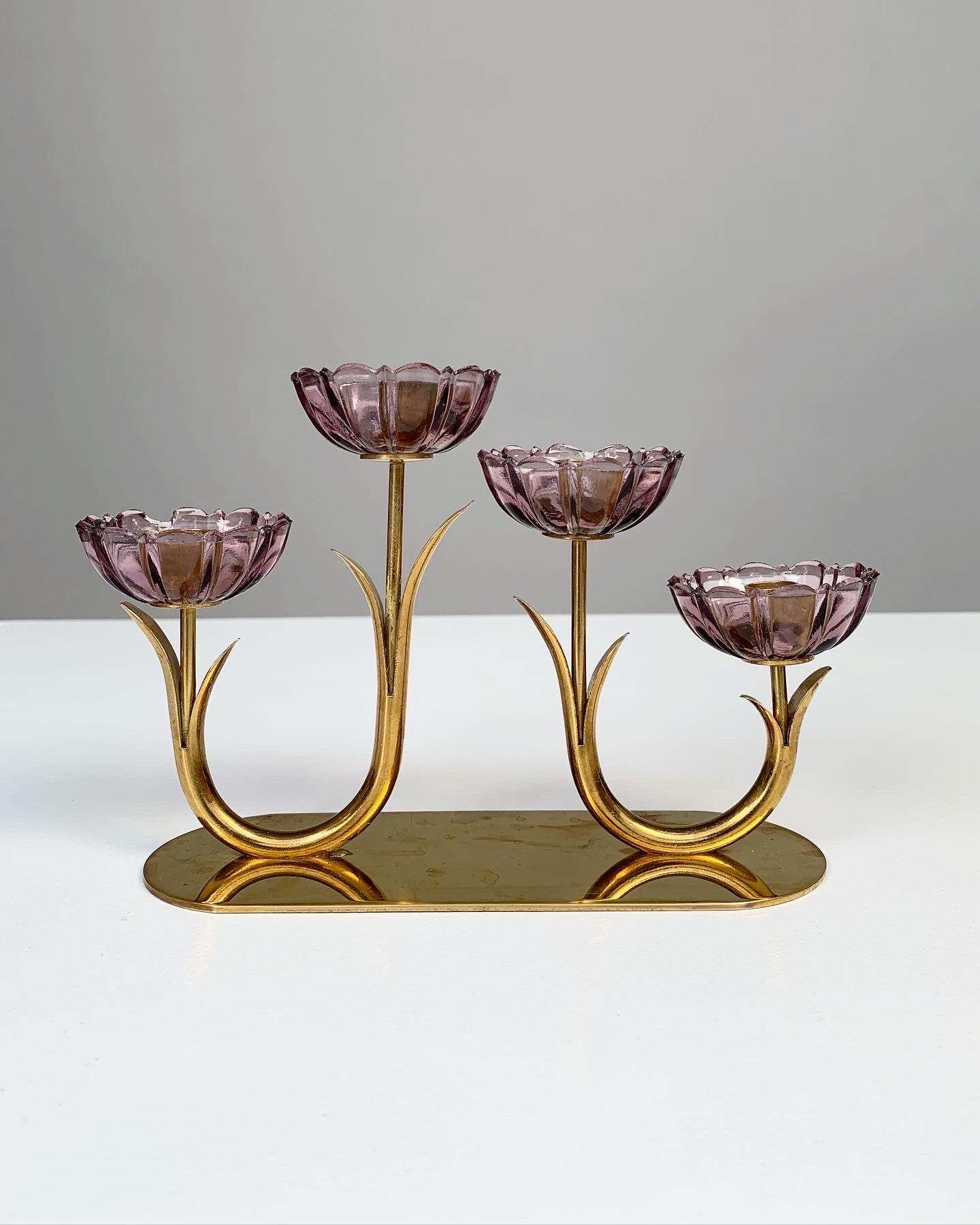 Flower candelabra designed by Gunnar Ander for Ystad-Metall in Sweden, 1950s.

Made of solid brass with lilac pressed glass flowers, marked „made in Sweden“.

Width: 18 cm
Depth: 6.5 cm
Height: 13 cm
For candles with a diameter of