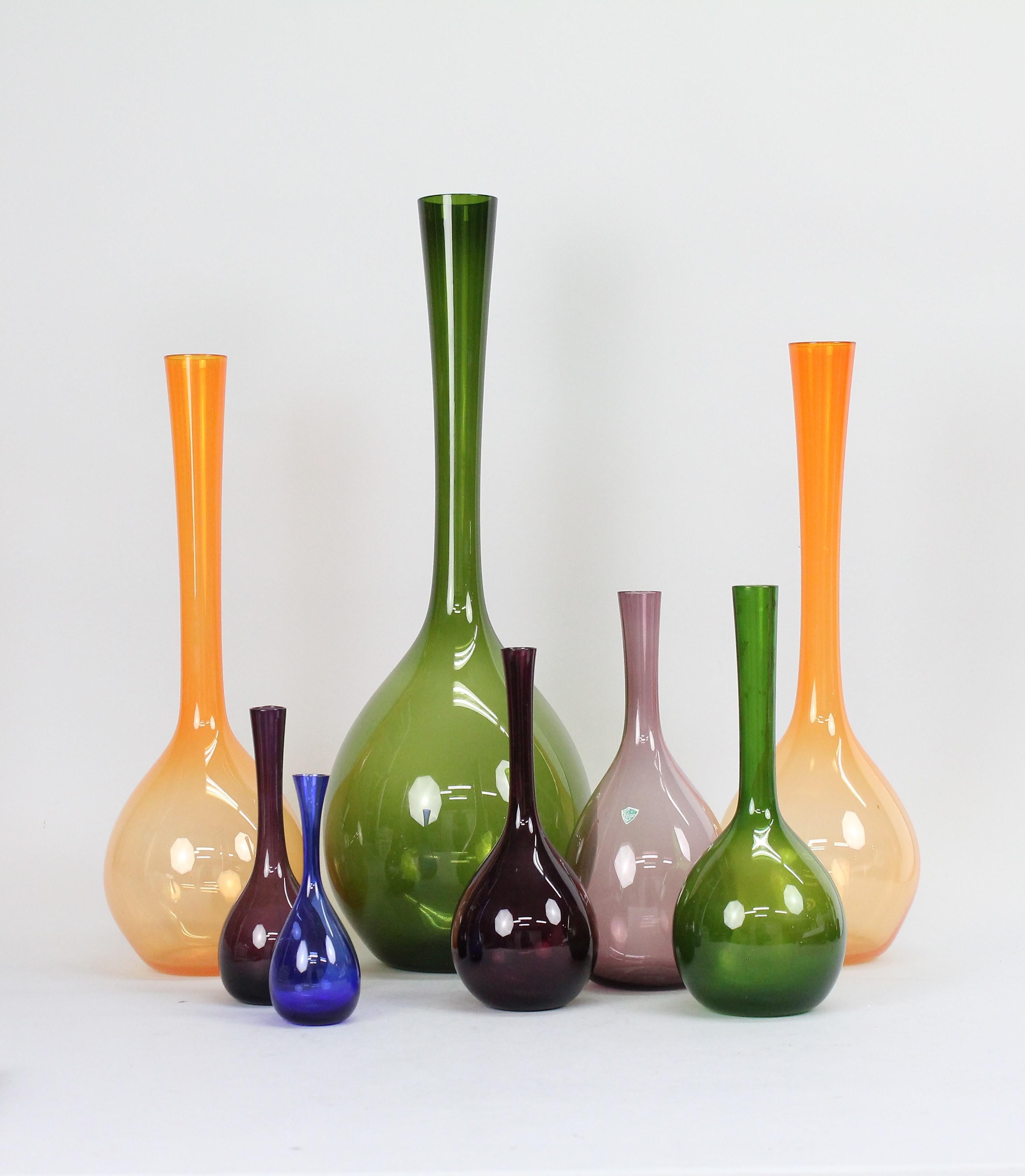 A wonderful modernist set of eight 1960s glass vases. 
In four different colours and 7 different heights, these really make a strong impression standing on a piece of furniture!

Size, tallest 50cm (19.7in), shortest 14cm (5.5in).
The colours