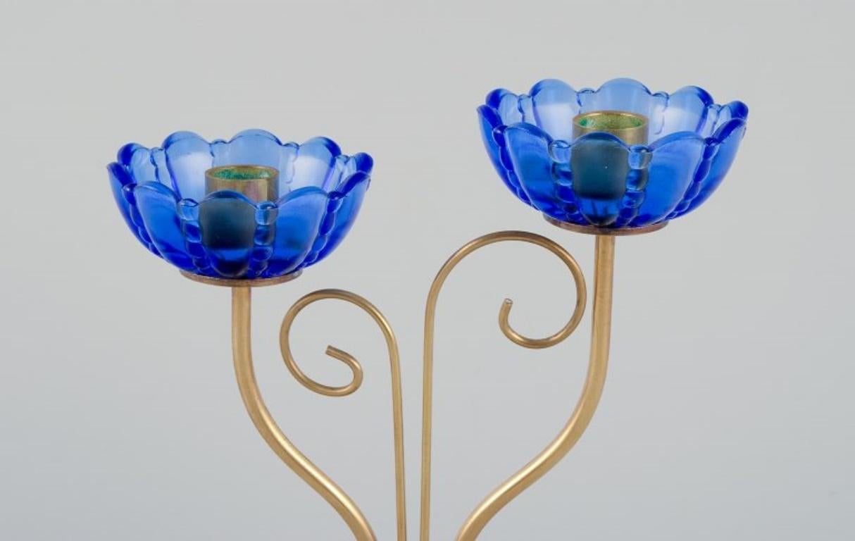 Swedish Gunnar Ander for Ystad Metall.  Brass candlestick holder with blue glass sleeves For Sale