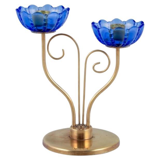 Gunnar Ander for Ystad Metall.  Brass candlestick holder with blue glass sleeves For Sale