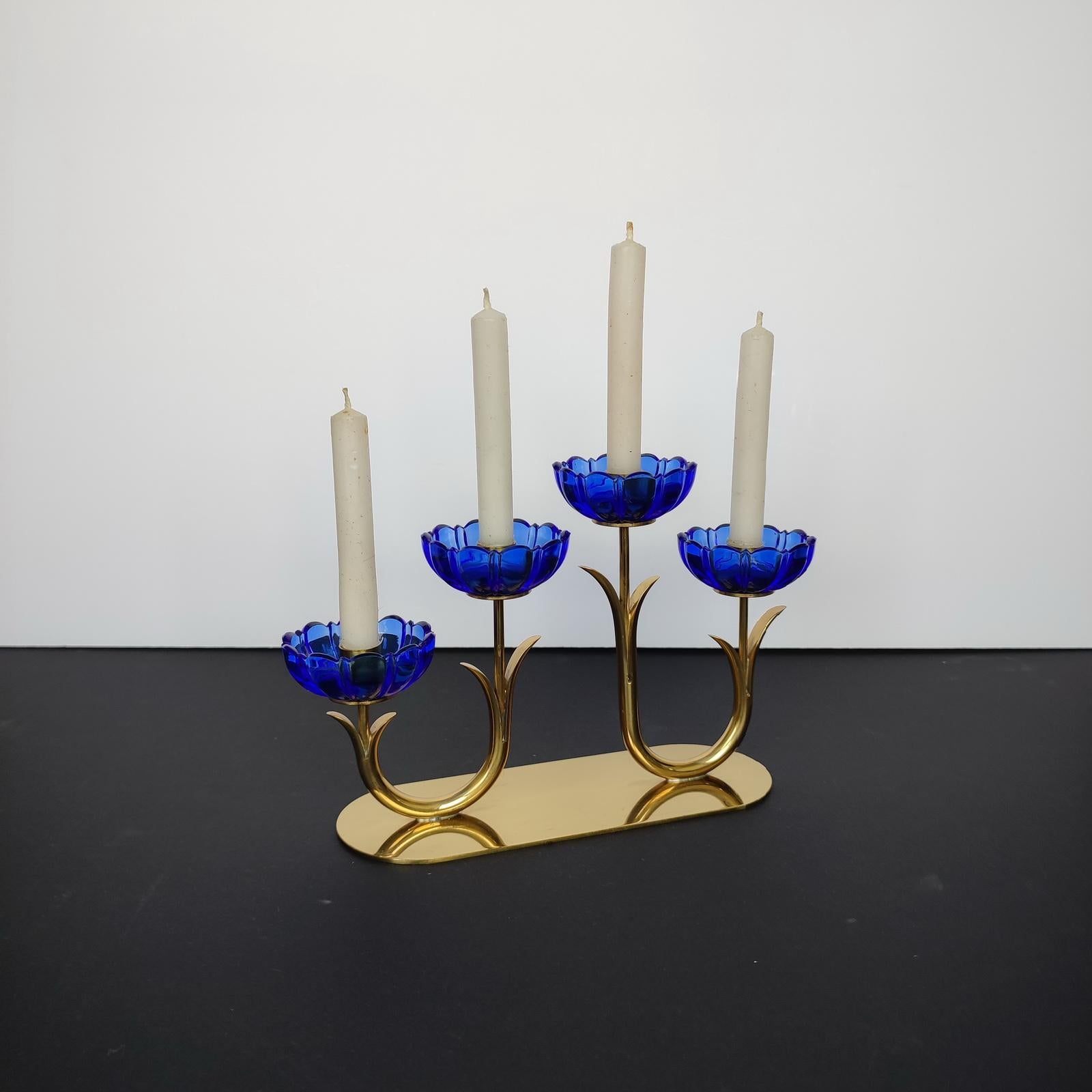 Gunnar Ander for Ystad Metall. Candlestick in brass and blue art glass shaped like flowers. 1950s. Maker's mark underneath. In very good used condition.
Dimensions: 21 x 12.5 x 6.5 cm.
Four lights candlestick, ideal for a Christmas present!.
