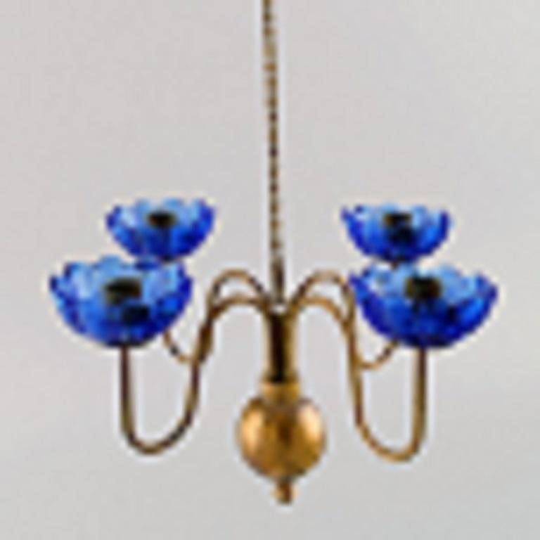Gunnar Ander for Ystad Metall. Chandelier for four candles in brass and mouth-blown art glass shaped like flowers. 
Scandinavian design, mid 20th century.
Measures: 21 x 12.5 cm.
Chain length: 72 cm.
In excellent condition.