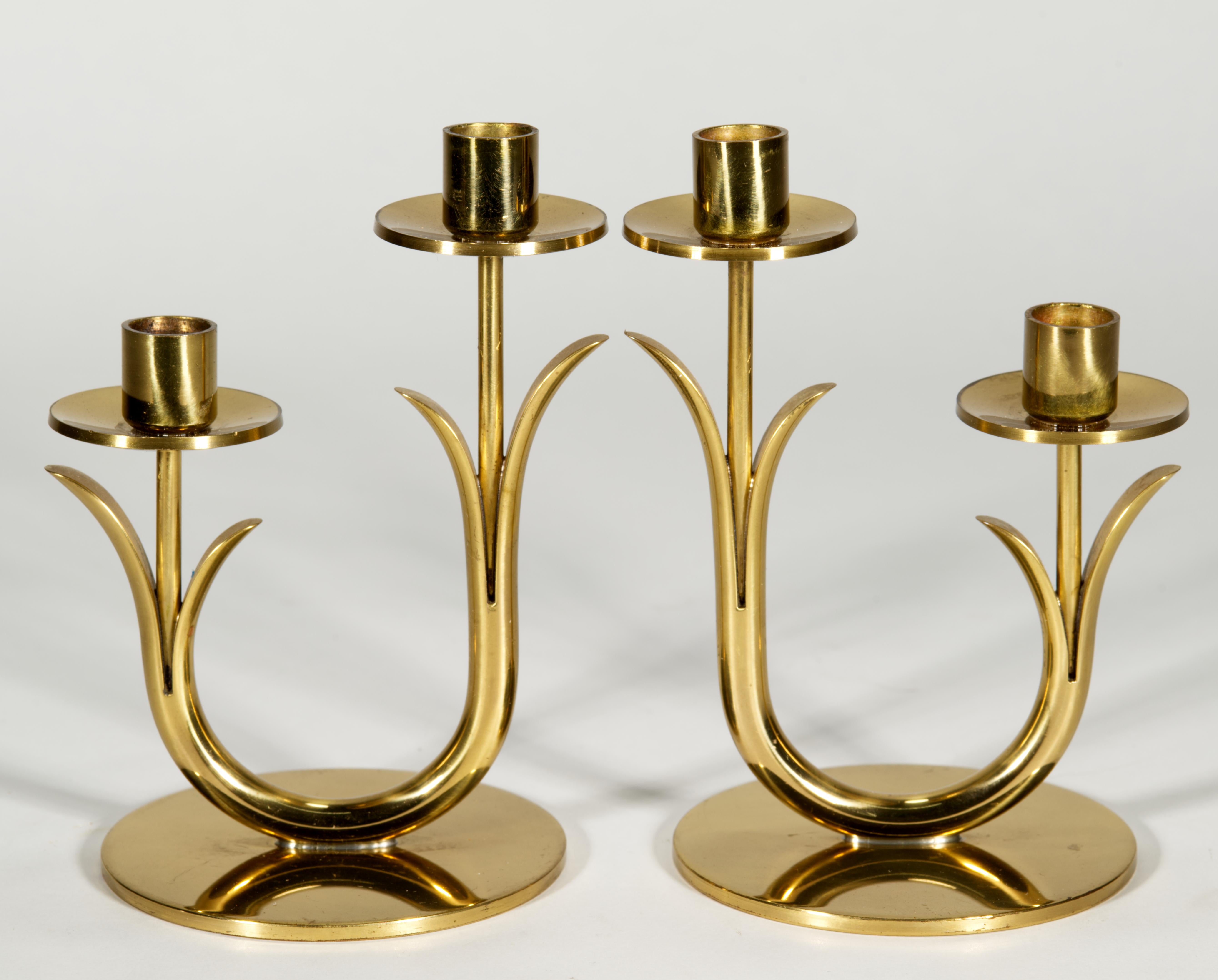 La coppia di candelieri vintage a due bracci in ottone è stata disegnata da Gunner Ander e prodotta per Ystad-Metall in Svezia. I bracci dalla forma organica e arrotondata con elementi astratti a forma di foglia sorreggono le applique con bobeches