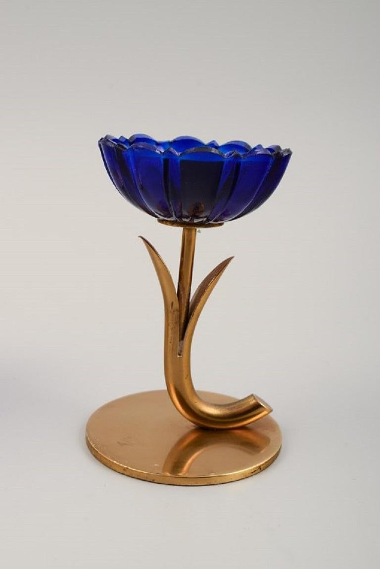 Gunnar Ander for Ystad Metall. Three candlesticks in brass and blue art glass shaped like flowers.
1950s.
Measurements: H 9.0 cm. x W 6.0 cm.?
Fits candles with a diameter of 10 mm.
In excellent condition.