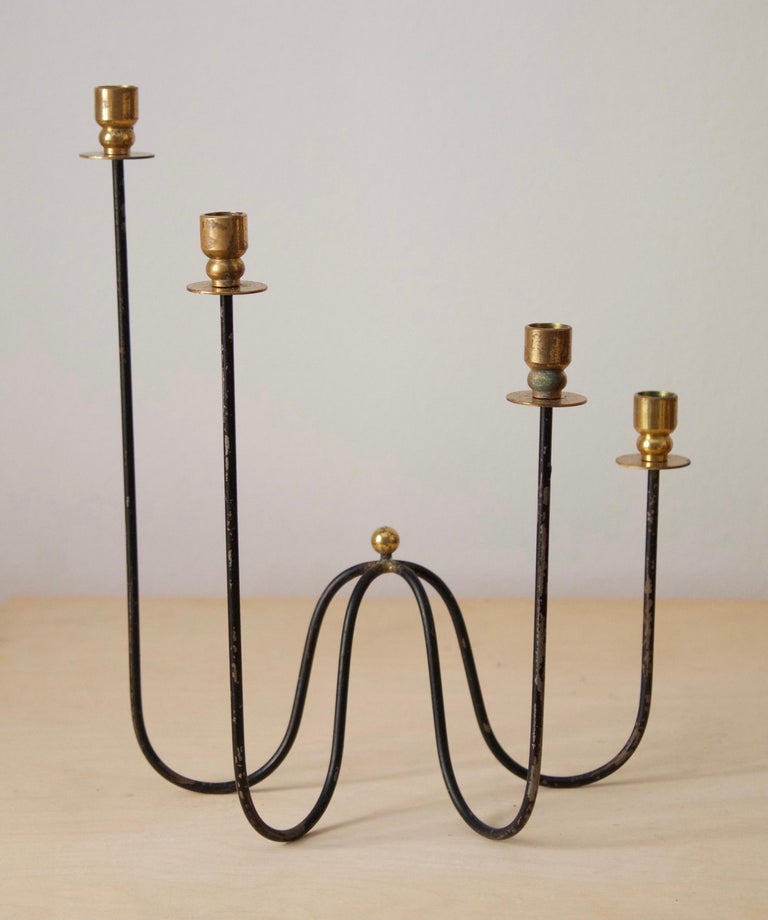 A small candelabra, attributed to Gunnar Ander for Ystad Metall, Sweden, 1950s. In brass and lacquered steel. For small candles. 

Other designers of the period include Piet Hein, Paavo Tynell, Josef Frank, and Jean Royère.

