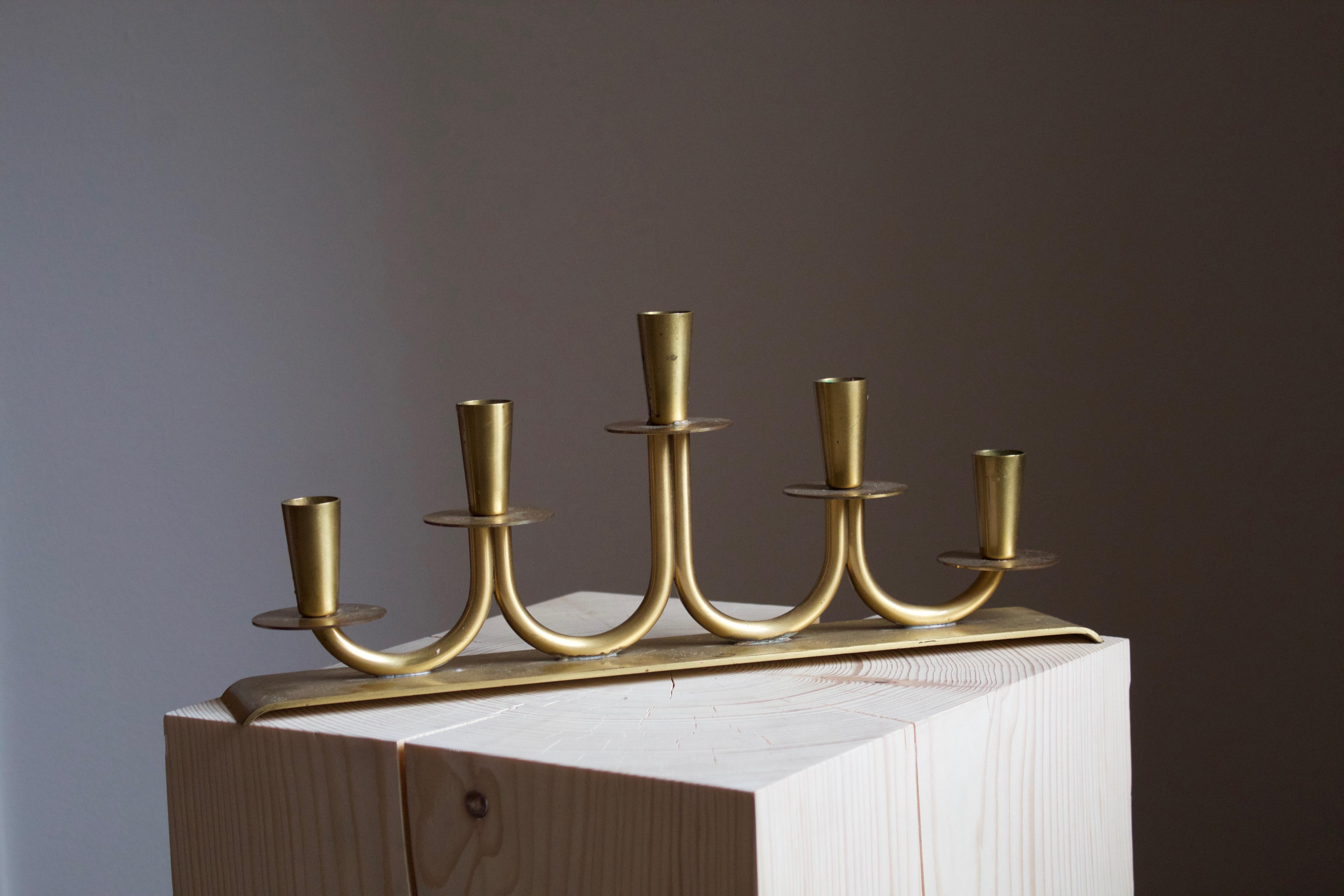 A candelabra / candleholder, designed by Gunnar Ander for Ystad Metall, Sweden, 1950s. In brass. Stamped.

Other designers of the period include Piet Hein, Paavo Tynell, Josef Frank, and Jean Royere.

 