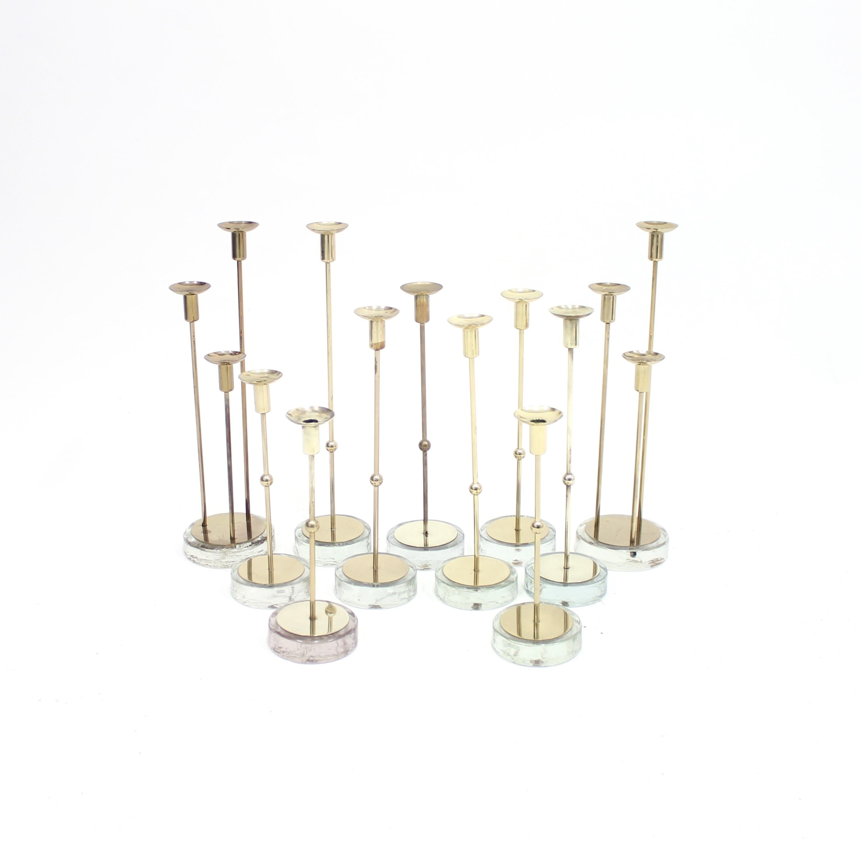 Set of 11 candleholders designed by Gunnar Under for Ystad Metall in the 1960s. The set includes all the models in this line. Three different heights for one candle and also the more rare variation for three candles. The models has a round glass