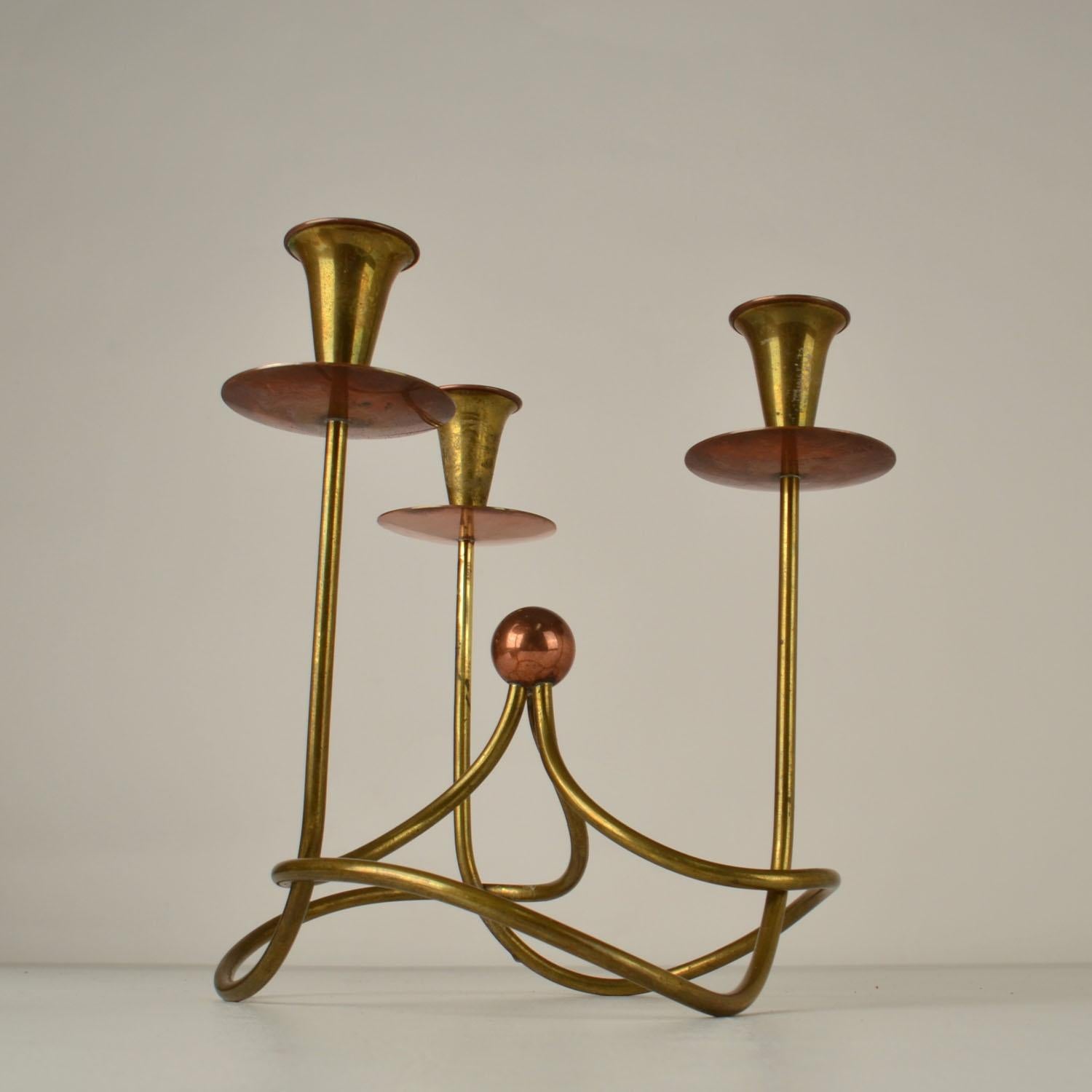 Il candelabro in rame e ottone di Gunar Ander, risalente alla metà del secolo scorso, è elegante. Ha tre bracci ed è adatto alle candele normali. È prodotto da Ystad-Metall, Svezia.