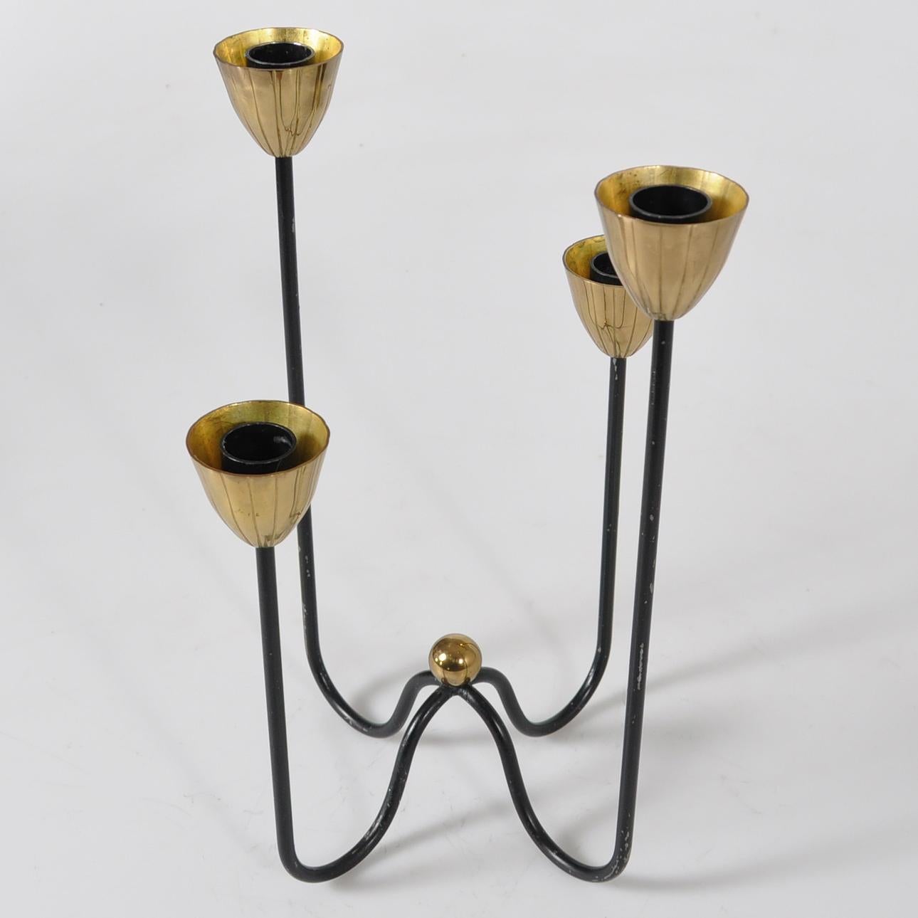 Descrizione:
Un sorprendente candelabro moderno di metà secolo disegnato da Gunnar Ander per Ystad-Metall in Svezia negli anni '50. Questo elegante portacandele a quattro bracci è caratterizzato da coppe in ottone scanalate poste in cima a sottili