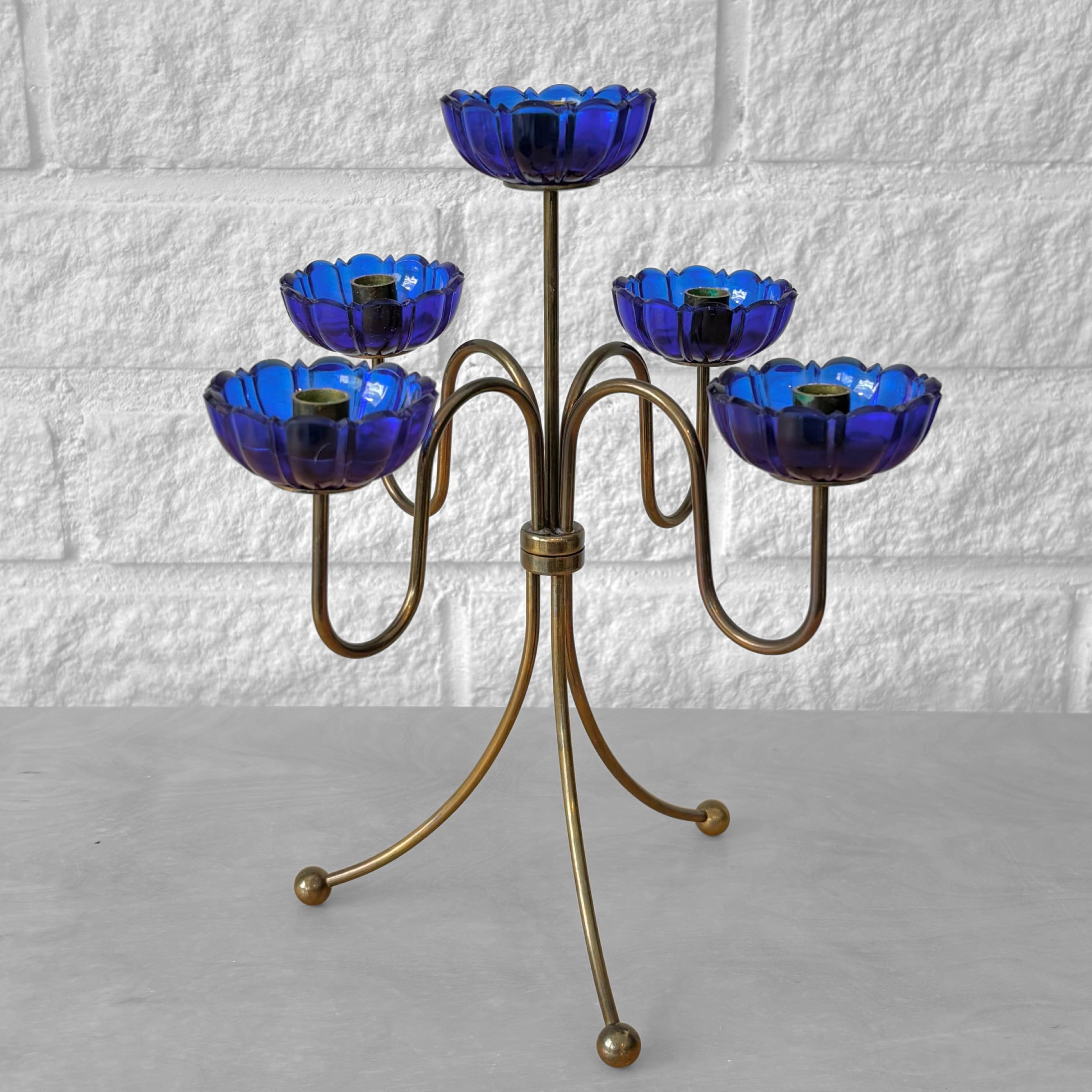 Un grazioso candelabro di metà secolo progettato da Gunnar Ander negli anni '60 per il produttore svedese Ystad-Metall. Realizzato in ottone, presenta cinque portacandele con manici in vetro blu. Il pezzo poggia su tre gambe ricurve, ognuna delle