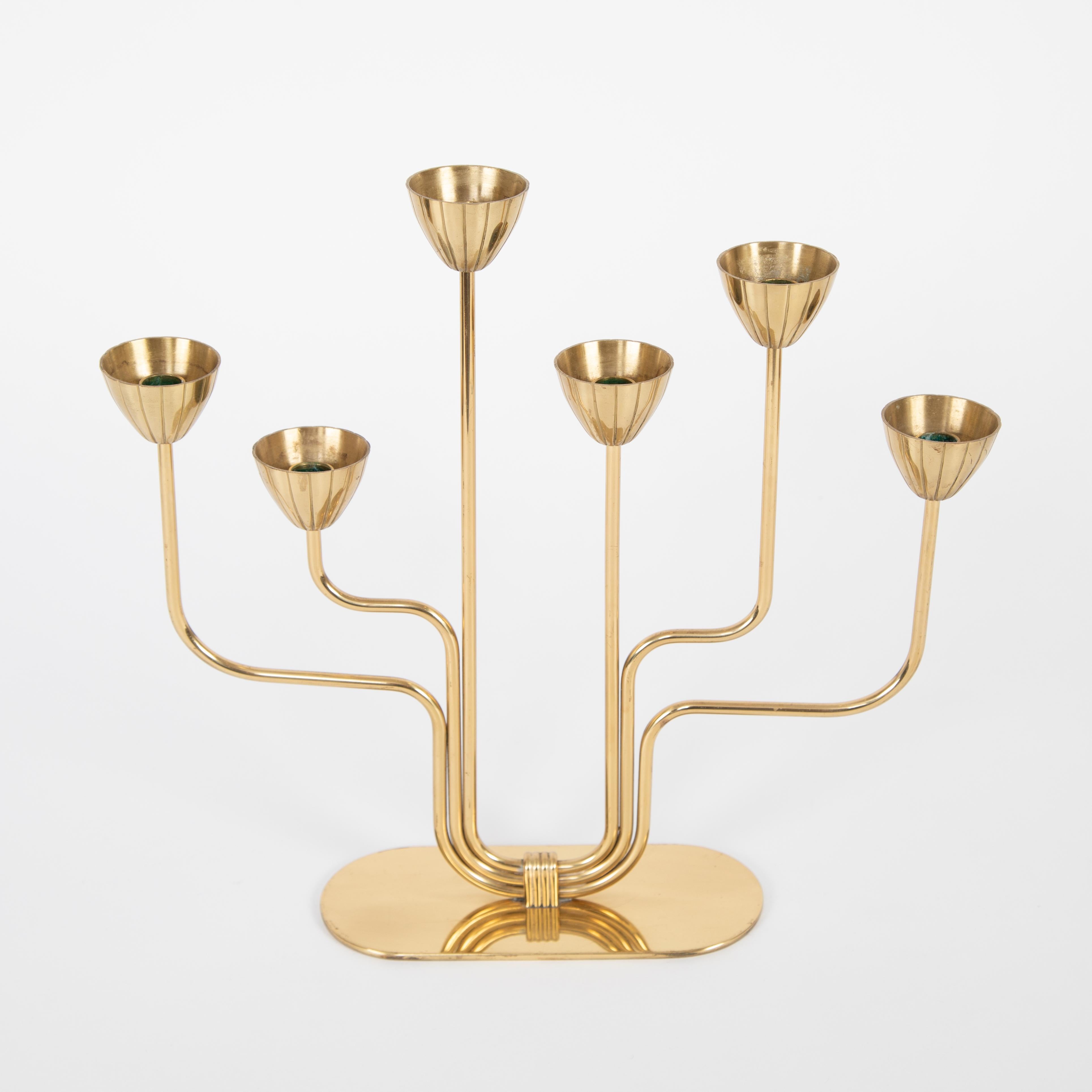 Elegant 1960s brass candelabrum designed by Gunnar Andersen for Ystad-Metall. Holds six slim 1/2-inch-diameter Swedish candles, or can be displayed without, as shown. Engraved maker's mark on bottom.


 