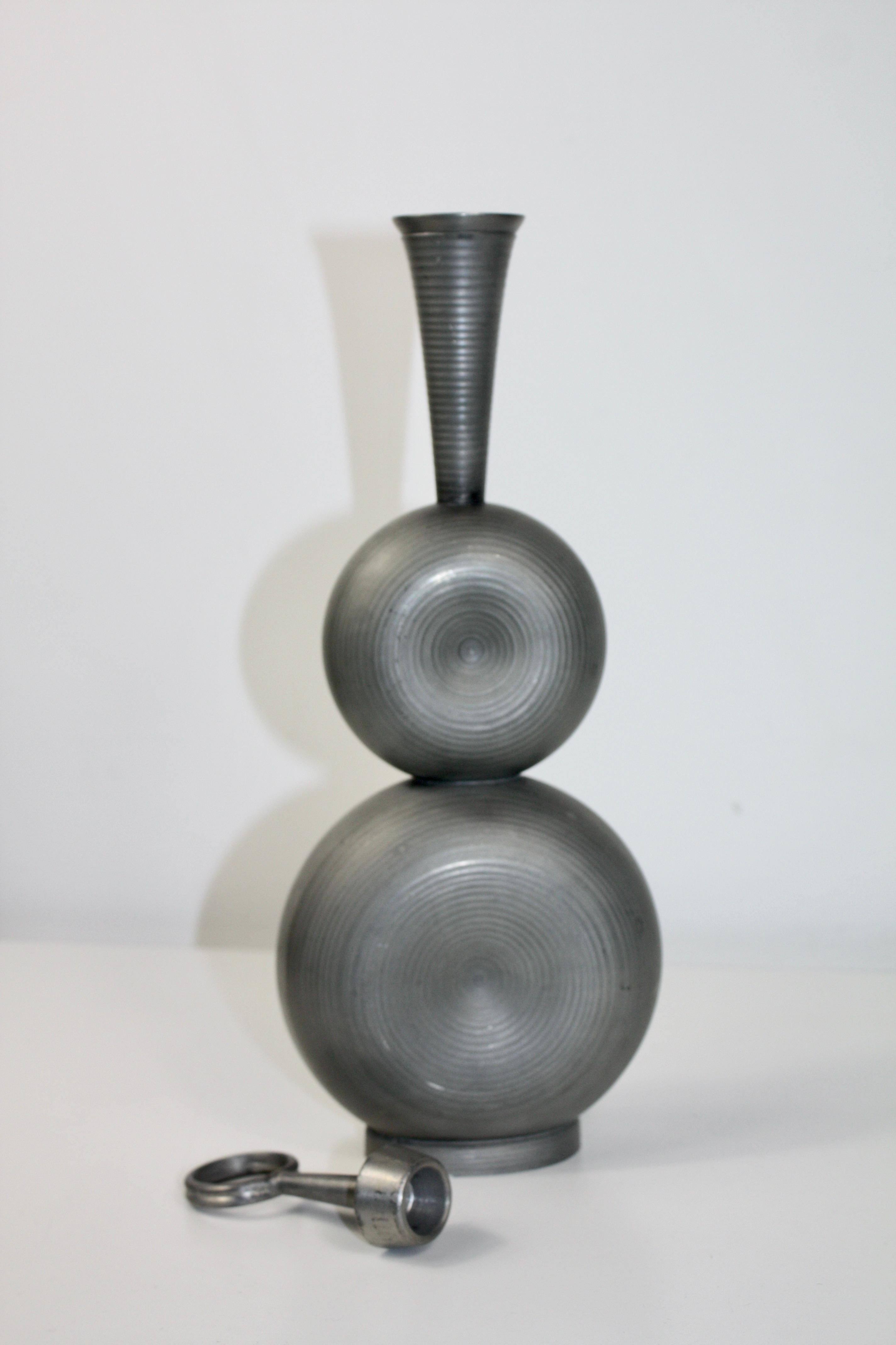 Un bellissimo decanter scultoreo in peltro con tappo di Gunnar Havstad.
Realizzato in Norvegia negli anni '50. Questo elegante decanter cattura l'essenza del Modern Design Scandinavo, un periodo caratterizzato da linee pulite, estetica funzionale e
