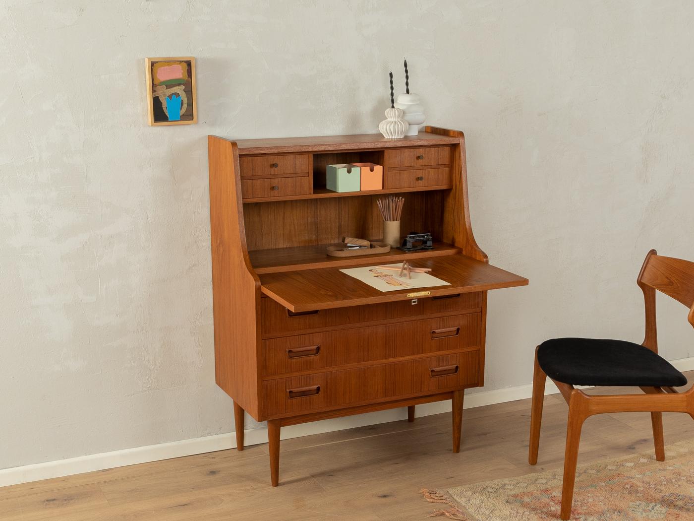 Classic secretary from the 1960s by Gunnar Nielsen for Tibergaard. High-quality corpus in teak veneer with a hinged work surface, four interior drawers, one compartments, three drawers and cigar shaped feet.
Working height 71 cm

Quality Features:
 