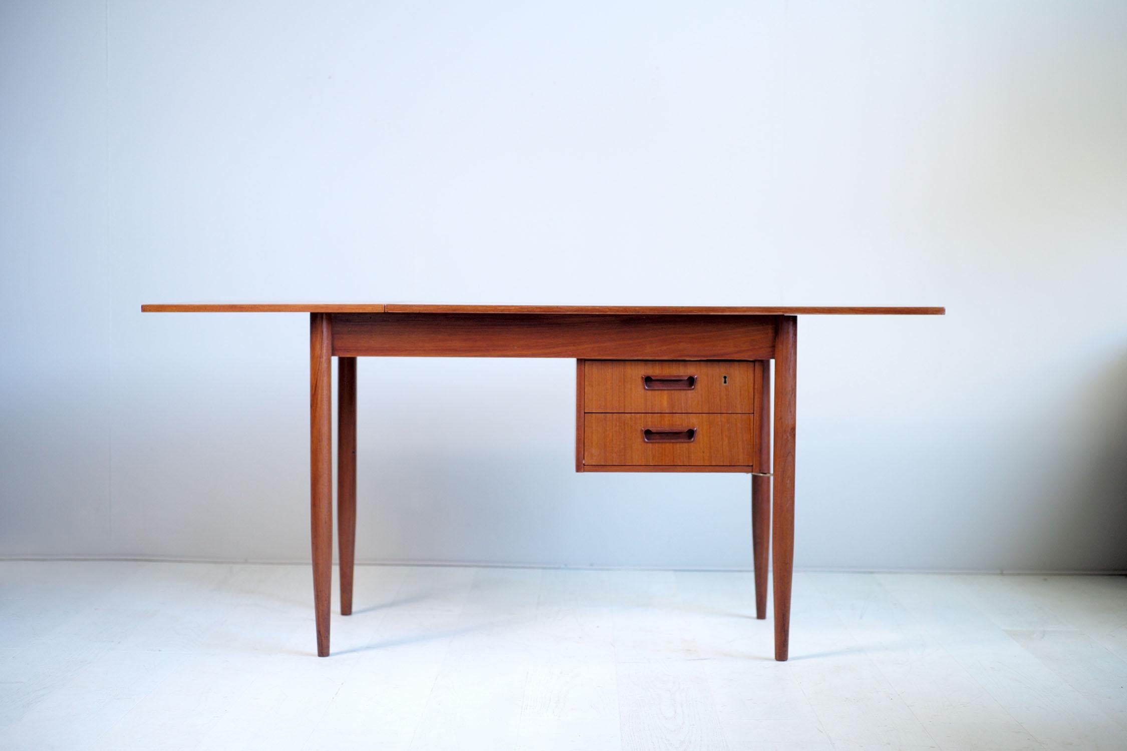 Gunnar Nielsen Tibergaard teak system desk, Denmark, 1960. The two-part articulated tray slides, the length goes from 115 com to 165cm. The double drawer box can be placed on the right or on the left, fixed by two golden brass tie rods. Marked with