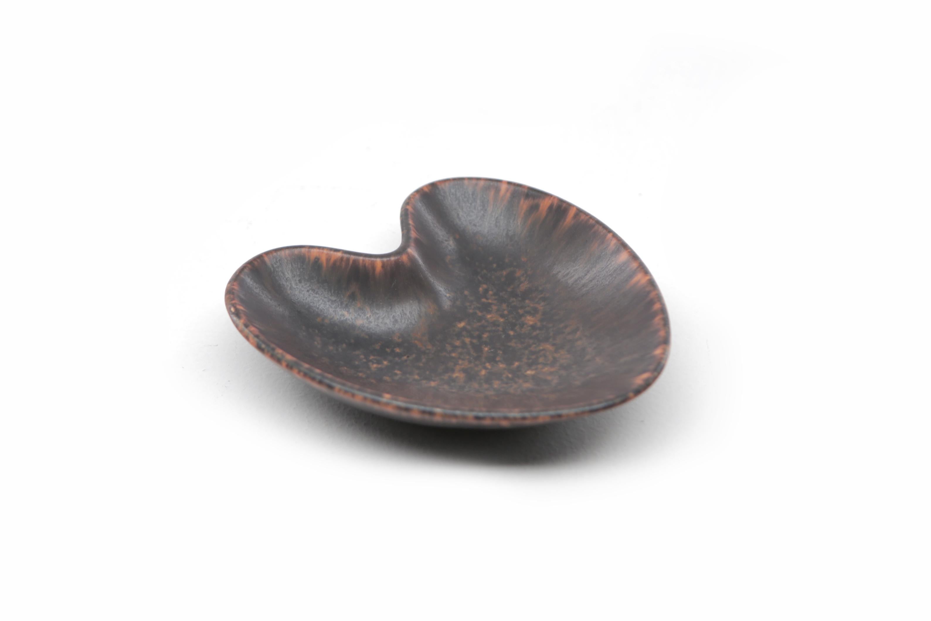 Gunnar Nylund AXA heart shaped brown bowl ochre rim for Rorstrand, Sweden, 1960s.

Measures: Length 13 cm
Width 11 cm
Height 5 cm

Incised 