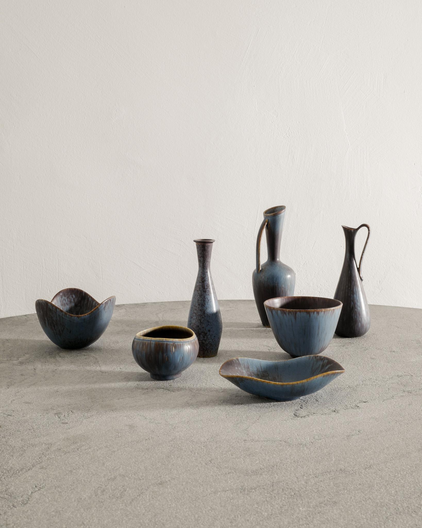 Raro set di sette vasi e ciotole in ceramica e gres svedese della metà del secolo scorso, smaltati con pelliccia di lepre blu e marrone da Gunnar Nylund per Rörstrand Sweden, anni '50. In buone condizioni originali e corrispondenti, tutti firmati