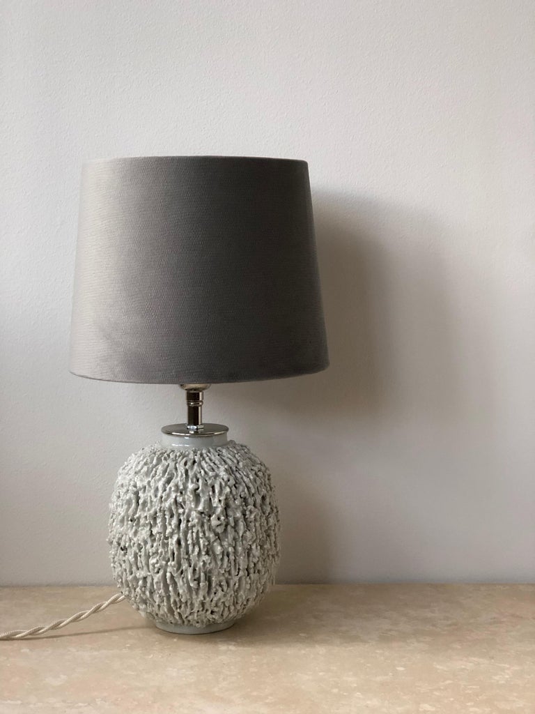 Scandinavian modern rare ceramic lamp by Gunnar Nylund for Rörstrand, Sweden. The lamp was made in the 1940s of chamotte clay and finished with a cream colored luster glaze. Original bobeche in brass is matched with a new lamp holder in brass. New