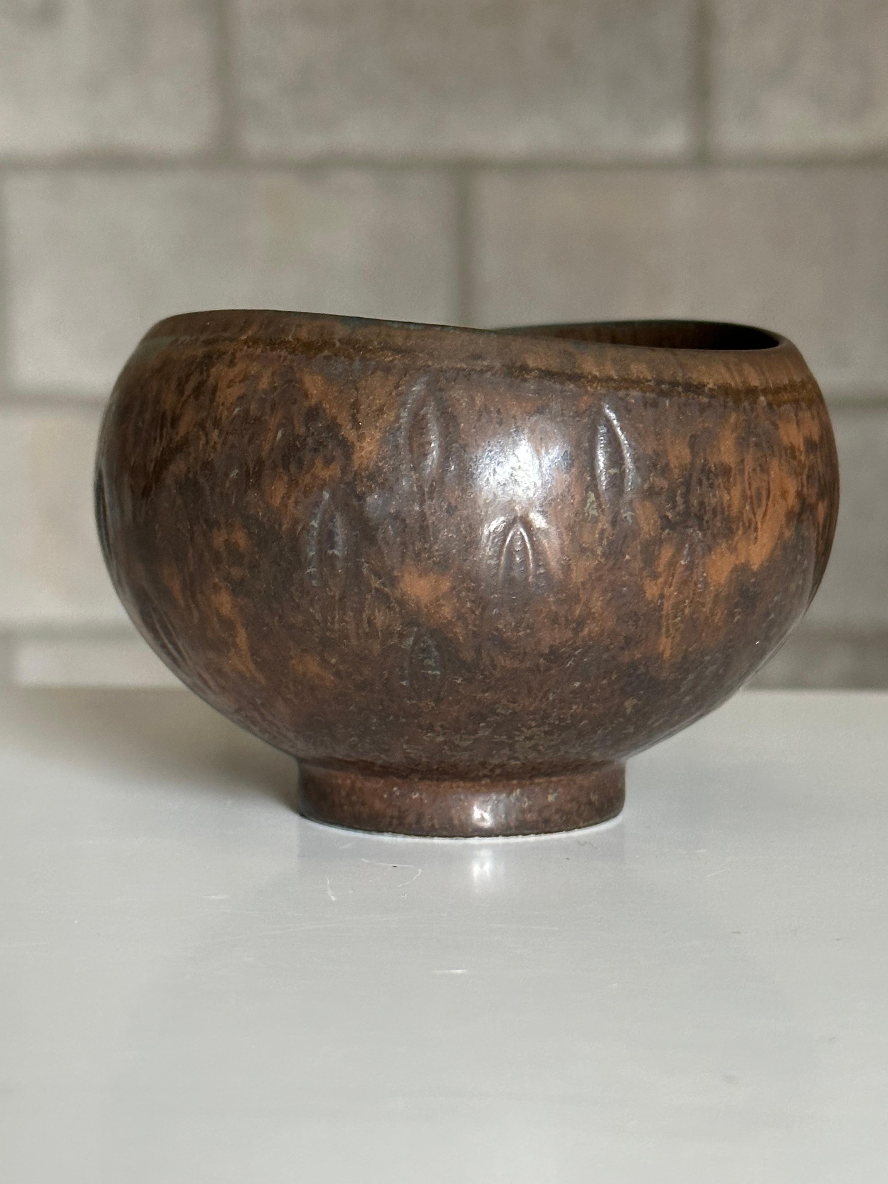 Wonderful small bowl designed by Gunnar Nylund for Rörstrand. Features a unique rust brown or terra-cotta bowl. Unusual patterning around exterior of bowl with an almost repeating leaf like motif. 
