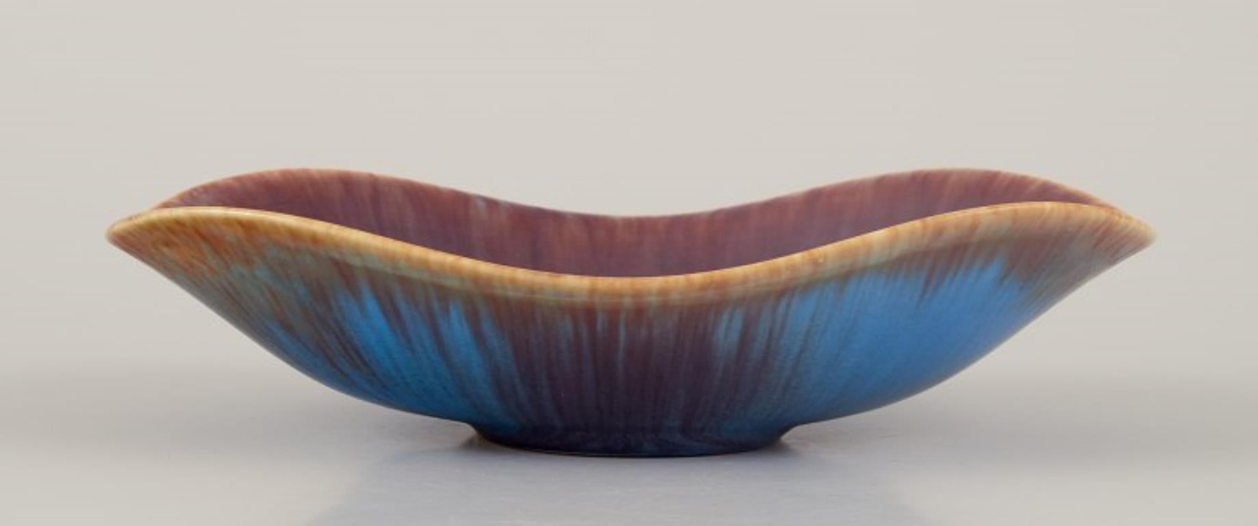Gunnar Nylund (1904-1997) pour Rörstrand, Suède.
Bol en céramique, émaillé dans les tons bleu-brun.
Milieu du 20e siècle.
Marqué.
En excellent état, avec de légères fissures de cuisson dues à la production. Voir la photo.
Deuxième qualité