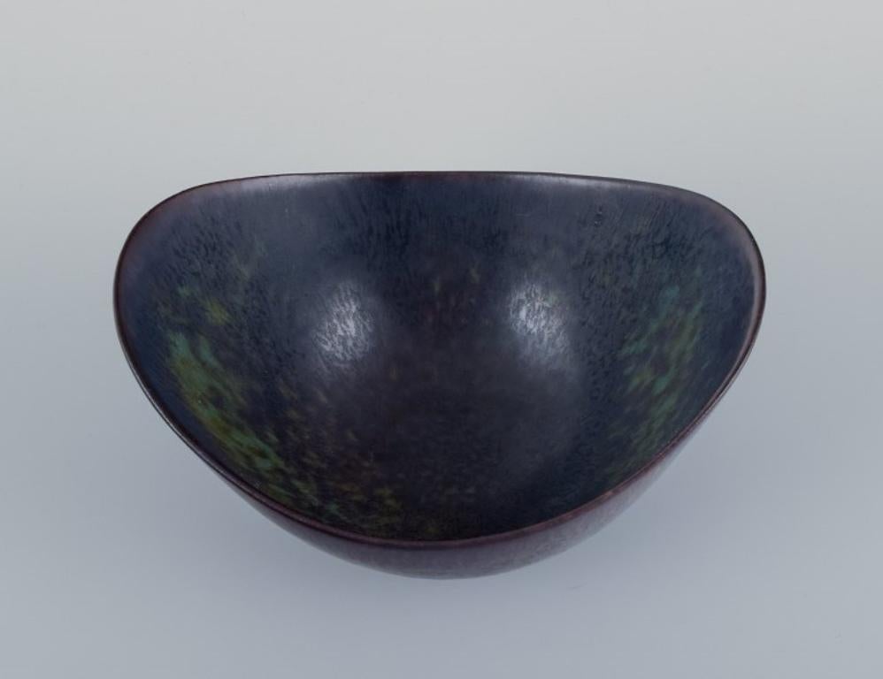 Gunnar Nylund (1904-1997) for Rörstrand.
Ceramic bowl with glaze in blue and brown tones.
Mid-20th century.
In perfect condition.
First factory quality.
Marked.
Dimensions: L 15.8 cm x W 12.2 cm x H 8.0 cm.

Gunnar Nylund is widely recognized as a