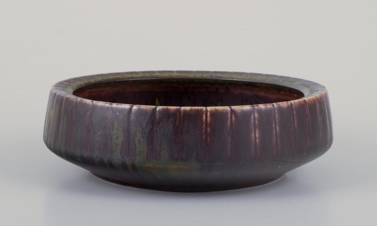 Gunnar Nylund per Rörstrand, Svezia. 
Ciotola in ceramica con smalto nei toni del marrone e del verde.
Metà del XX secolo.
Contrassegnato.
In perfette condizioni.
Prima qualità di fabbrica.
Dimensioni: D 17,5 cm x H 5,5 cm.