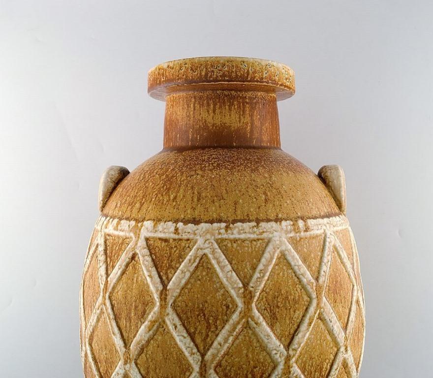 Gunnar Nylund for Rörstrand.
Colossal unique floor vase with geometric pattern in glazed stoneware. 
Beautiful glaze in light earth tones. 
Early unique piece from the 1940's in museum quality.
2nd factory quality.
In very good
