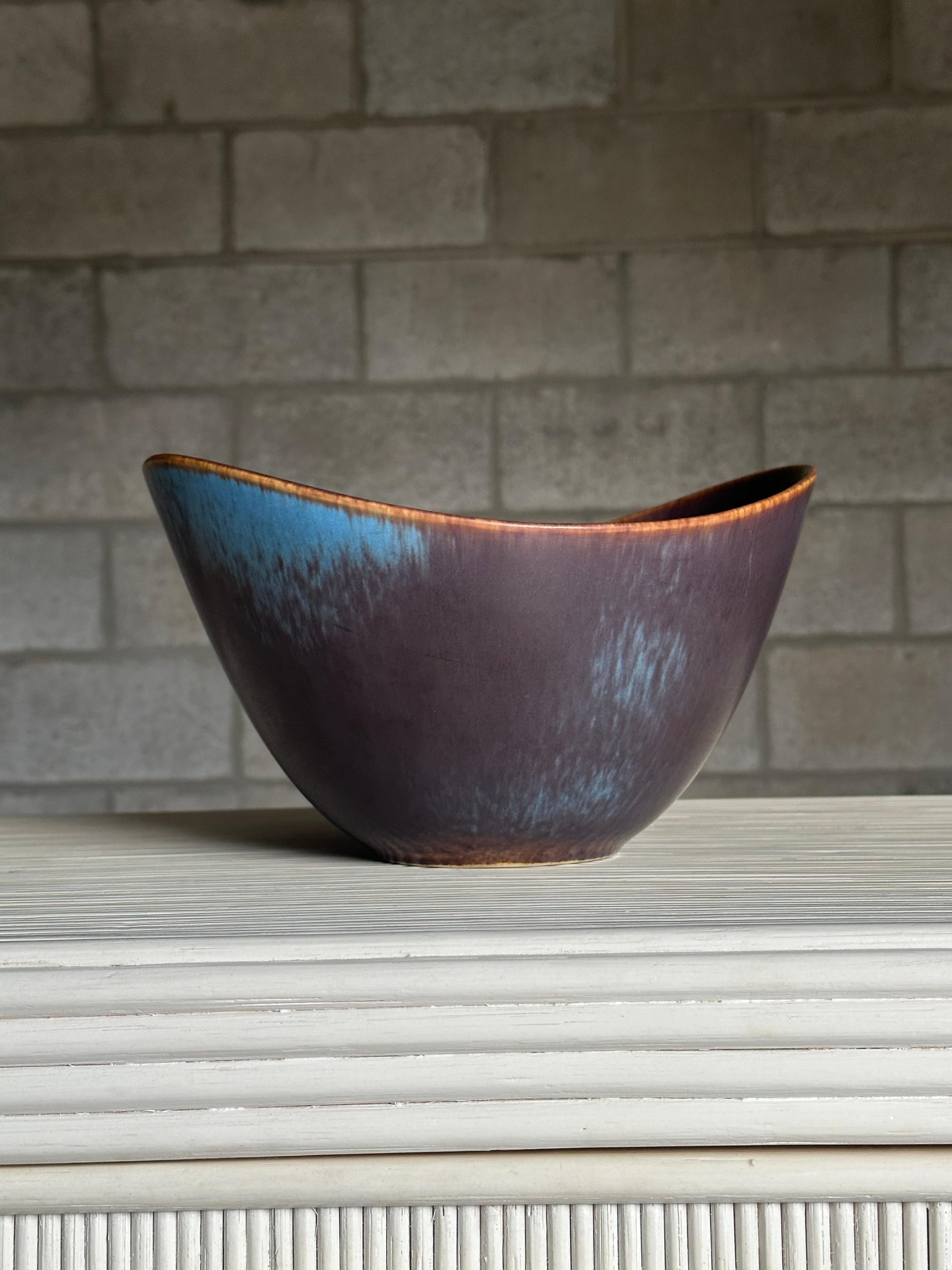 An impressive and large stoneware bowl designed by Gunnar Nylund for Rörstrand. Gorgeous coloring and great scale, the bowl has wonderful movement. Could be used as a fruit bowl, or simply on a shelf. A timeless form and color.