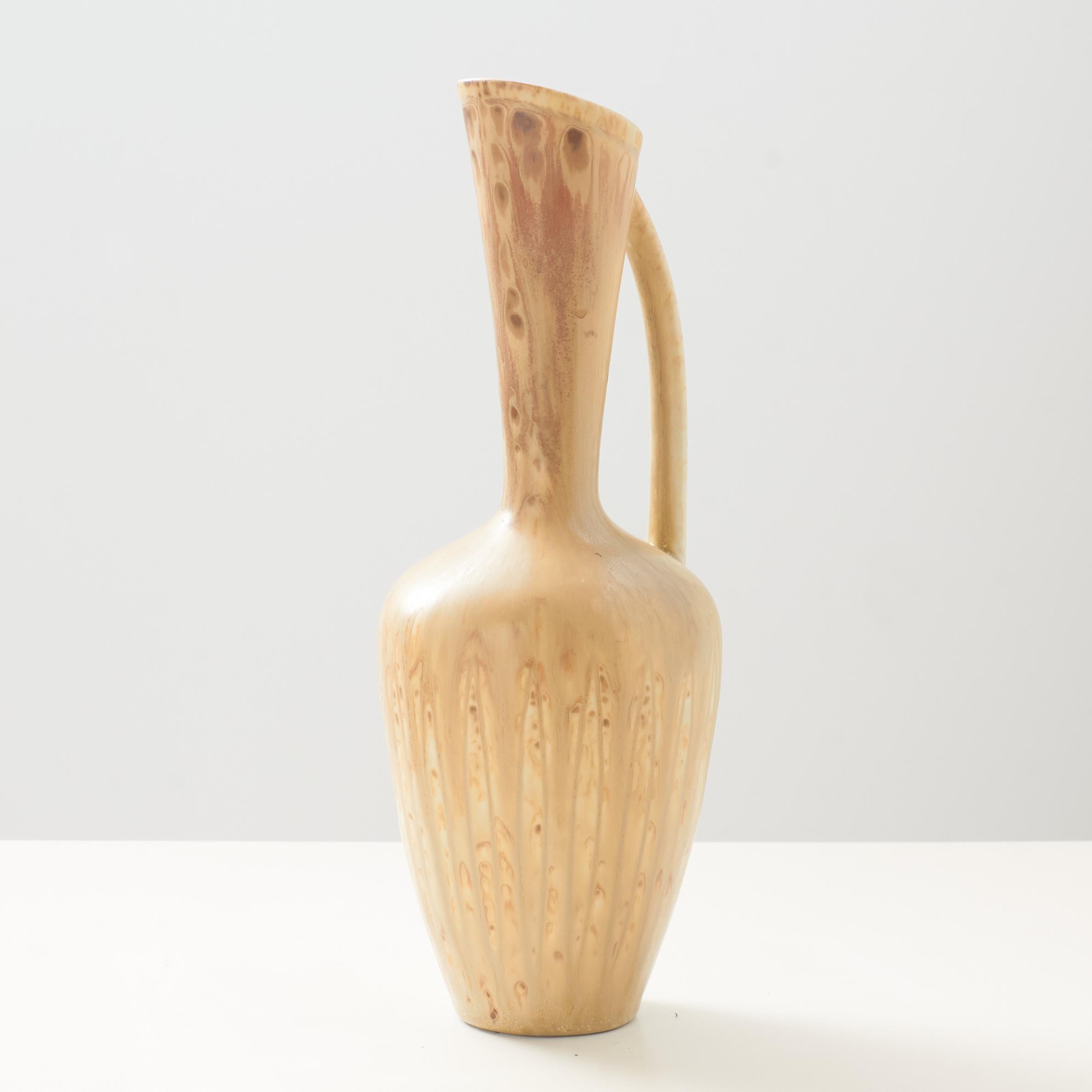 A very small pitcher or vase in beige by Gunnar Nylund for Rorstrand. Impressed on the base with both the creator and manufacturer's mark. 

Very good vintage condition. No chips or scratches.