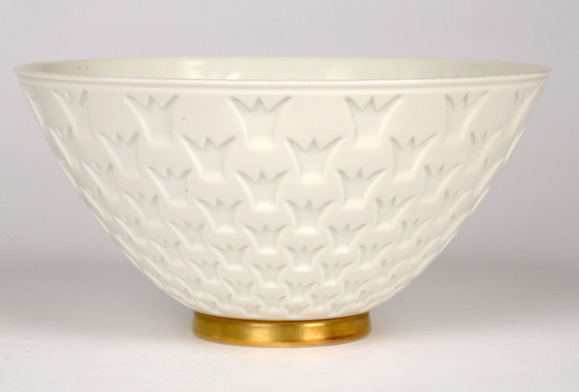 A very stylish and finely made Swedish Rörstrand porcelain bowl the body decorated with a crown window design by Gunnar Nylund (1904-97) and dating from around 1940. The lightly made bowl stands on a narrow rounded foot run with a gilded edge with a