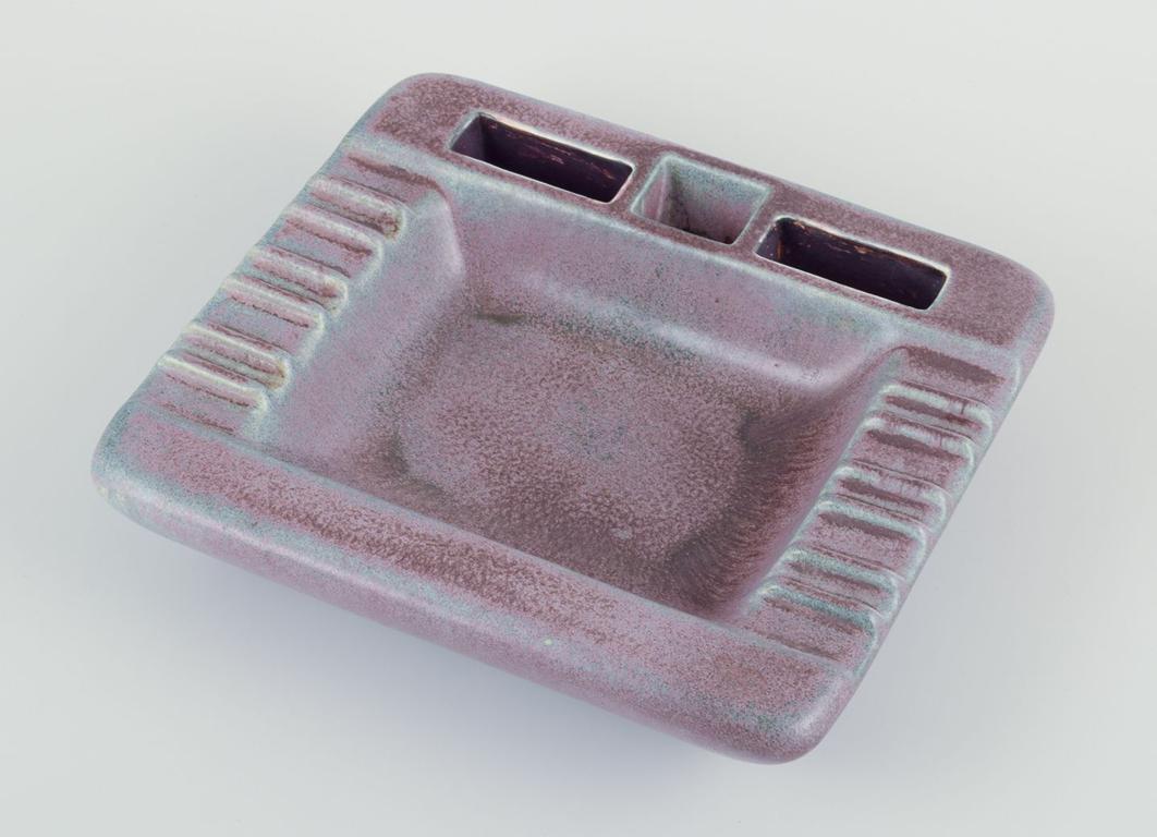 PRE-OWNED GOODS ARE EXEMPT FROM IMPORT TARIFFS FOR U.S., UK, AUSTRALIAN & CANADIAN CUSTOMERS.   
THEREFORE, NO IMPORT TARIFFS WILL BE APPLICABLE TO YOUR PURCHASE. 

Gunnar Nylund for Rörstrand.
Square ceramic cigar ashtray.
Glazed in blue and violet