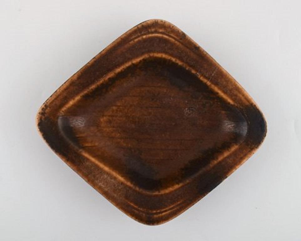 Gunnar Nylund for Rörstrand. Square dish in glazed stoneware. Beautiful glaze in brown shades. Rare form, 1960s.
Stamped.
Measures: 20 x 17.5 x 3 cm.
In very good condition. 1st factory quality.