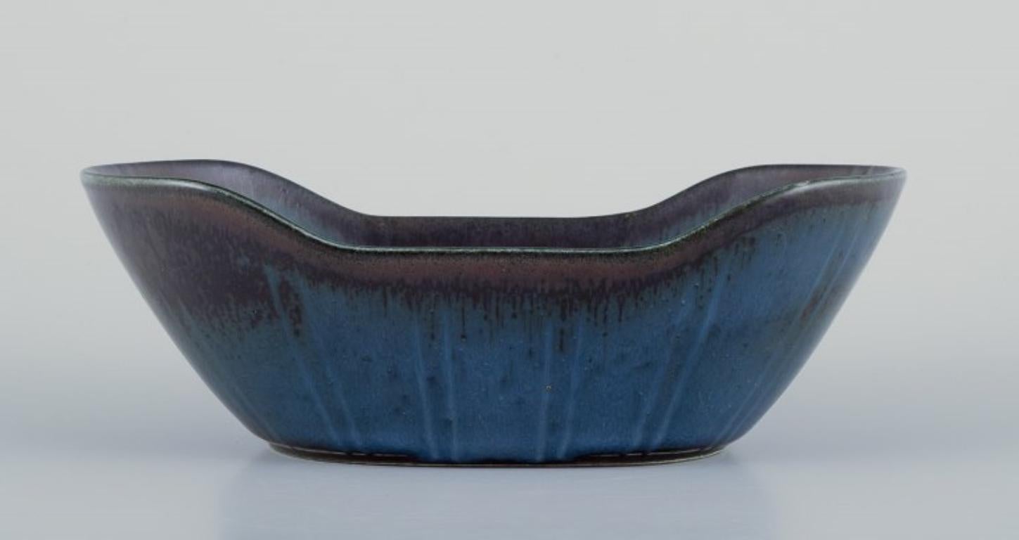 Gunnar Nylund (1904-1997) for Rörstrand, Sweden. 
Ceramic bowl in blue tones.
Mid-20th century.
Marked.
In perfect condition.
First factory quality.
Measurements: L 19.0 cm x W 11.0 cm x H 6.5 cm.

Gunnar Nylund is widely recognized as a prominent