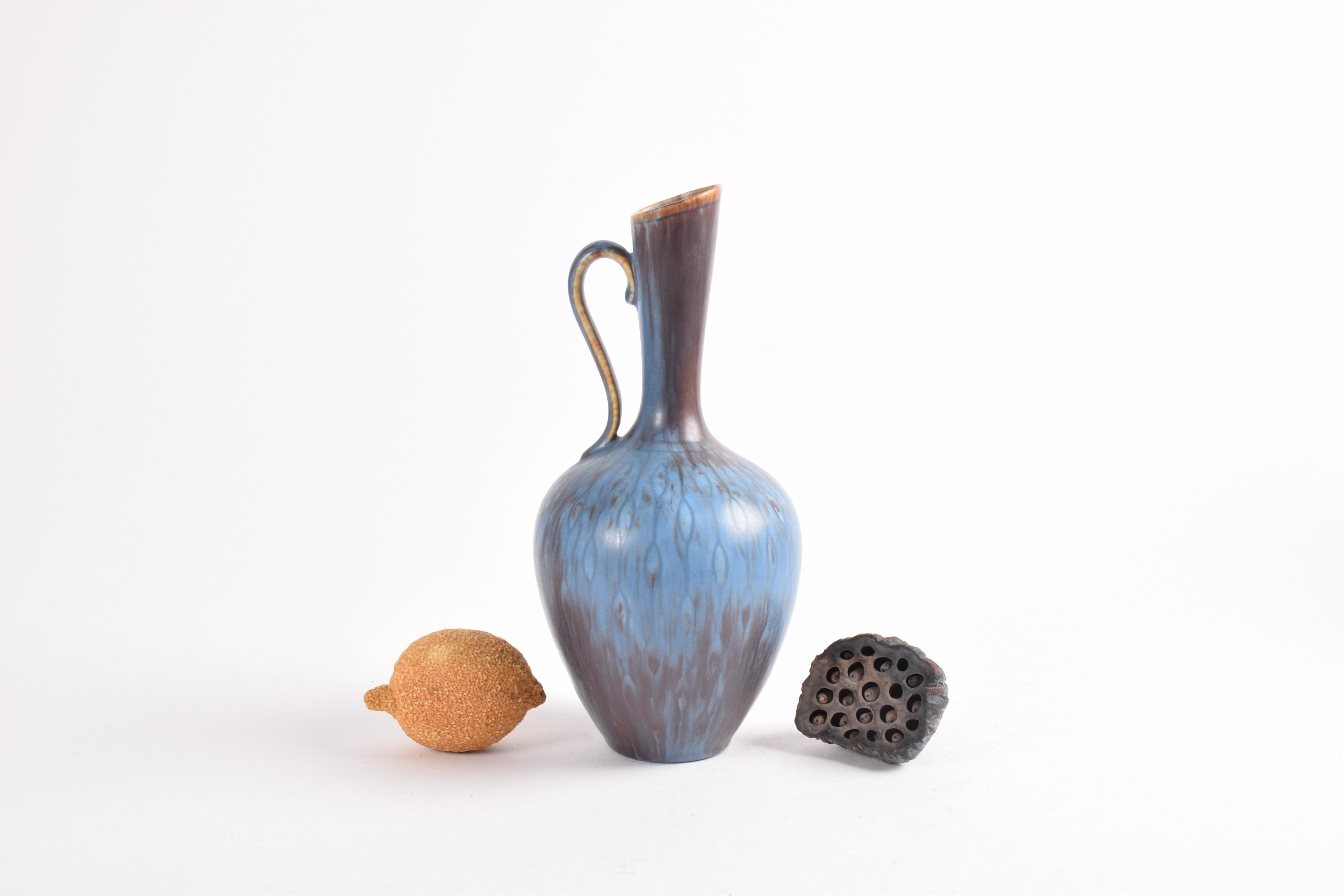 Elegant pitcher vase by Swedish designer Gunnar Nylund (1904-97) for Rörstrand, Sweden. Made ca 1950s to 1960s.

The vase is decorated with glaze in blue and brown / aubergine upon an incised pattern of teardrops in chains.

The vase is fully