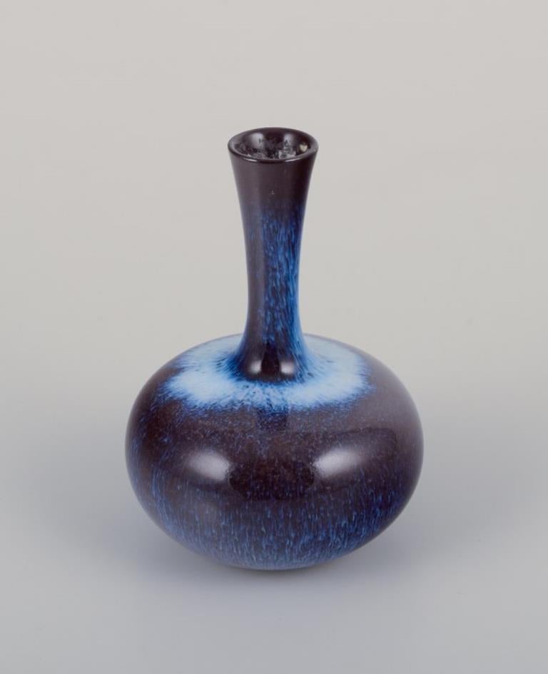 Gunnar Nylund (1904-1997) pour Rörstrand, Suède.
Vase Miniature au col élancé. Glacis dans les tons bleus et violets.
Milieu du 20e siècle.
Marqué.
En parfait état.
Deuxième qualité d'usine.
Dimensions : H 8,0 cm x P 5,5 cm : H 8,0 cm x D 5,5