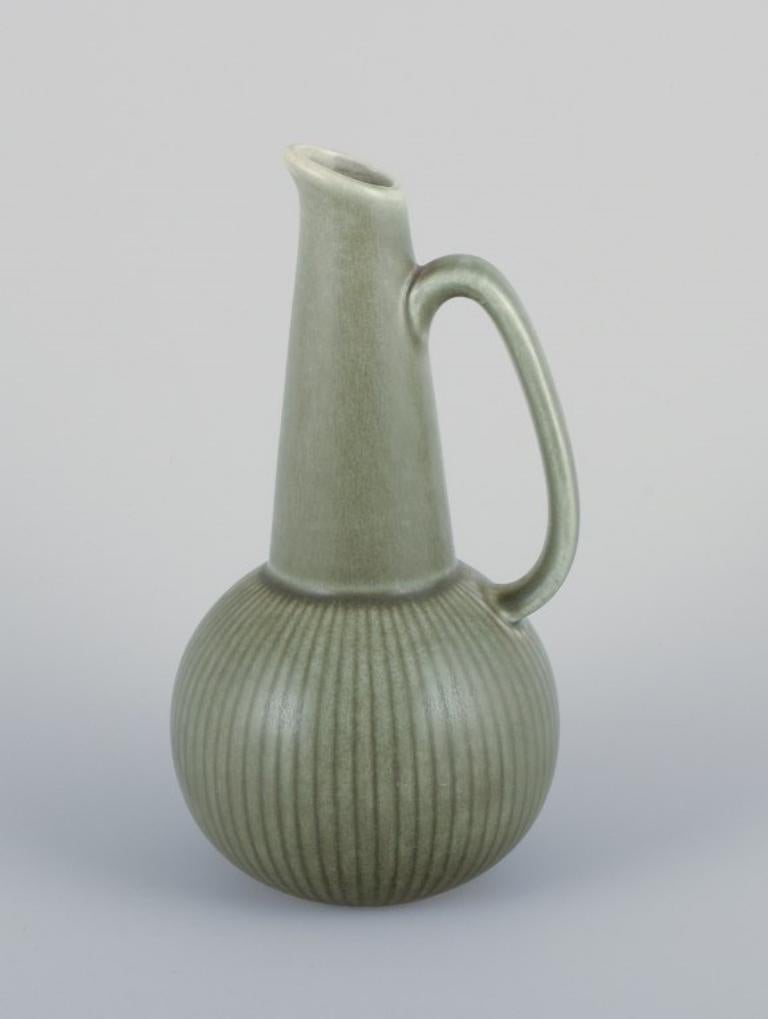 Gunnar Nylund (1904-1997) for Rörstrand, Sweden. 
A pair of Ritzi ceramic pitchers with green glaze.
From the 1960s.
Marked with the manufacturer's mark.
In perfect condition.
First factory quality.
Dimensions: Height 18.0 cm x Diameter 9.5