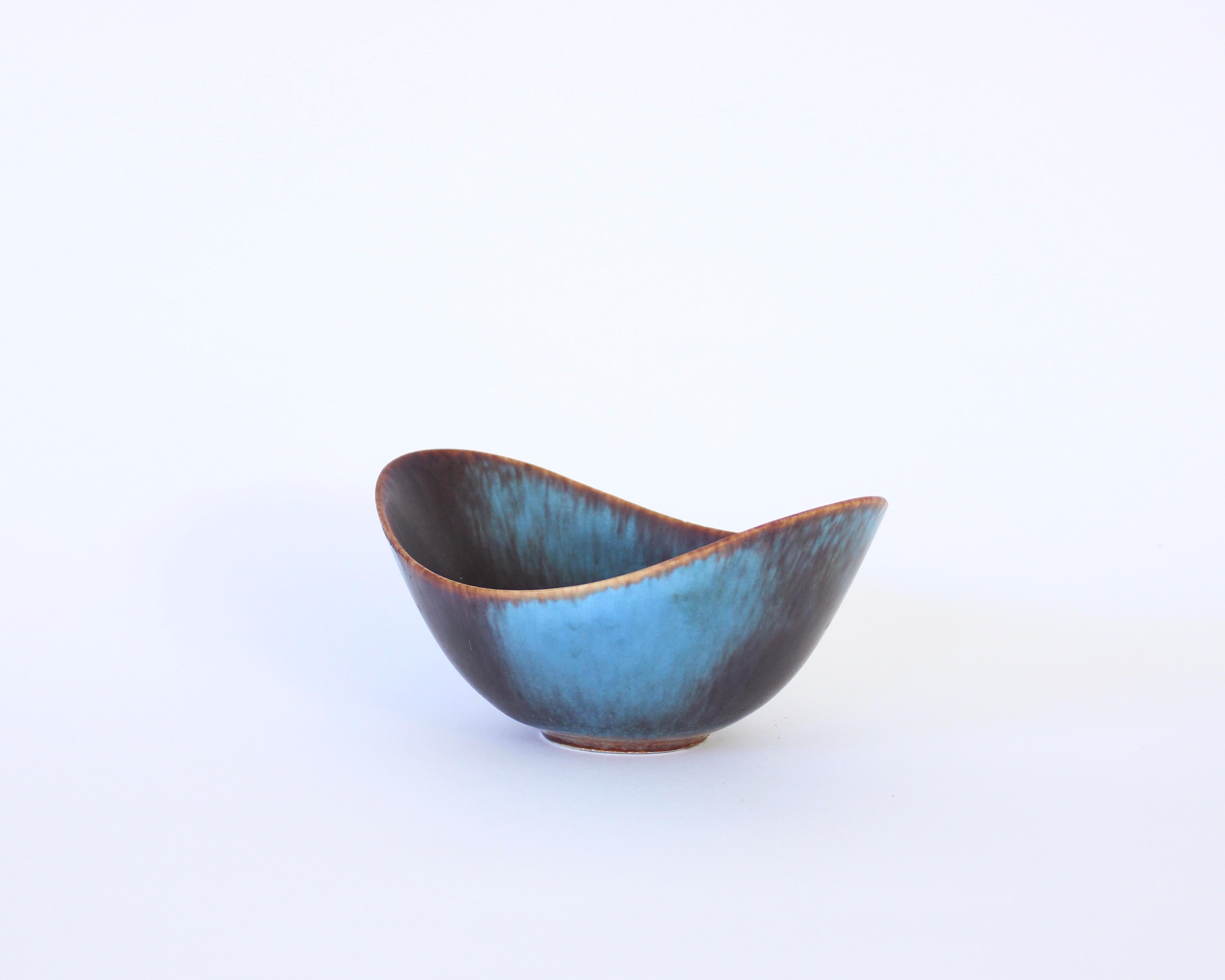 Medium size ARO bowl created and designed by Gunnar Nylund at the Rörstrand Factory in the 1950s, Sweden.
Blue hares fur glaze breaking to browns. Excellent condition. No chips.