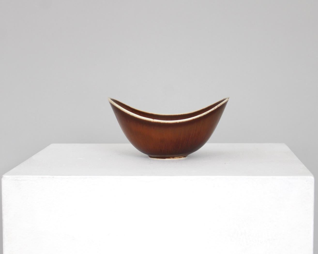 Medium size ARO bowl created and designed by Gunnar Nylund at the Rörstrand Factory in the 1950s, Sweden.
Brown hares fur glaze breaking to blacks with beautiful white rim. 
Excellent condition. No chips.