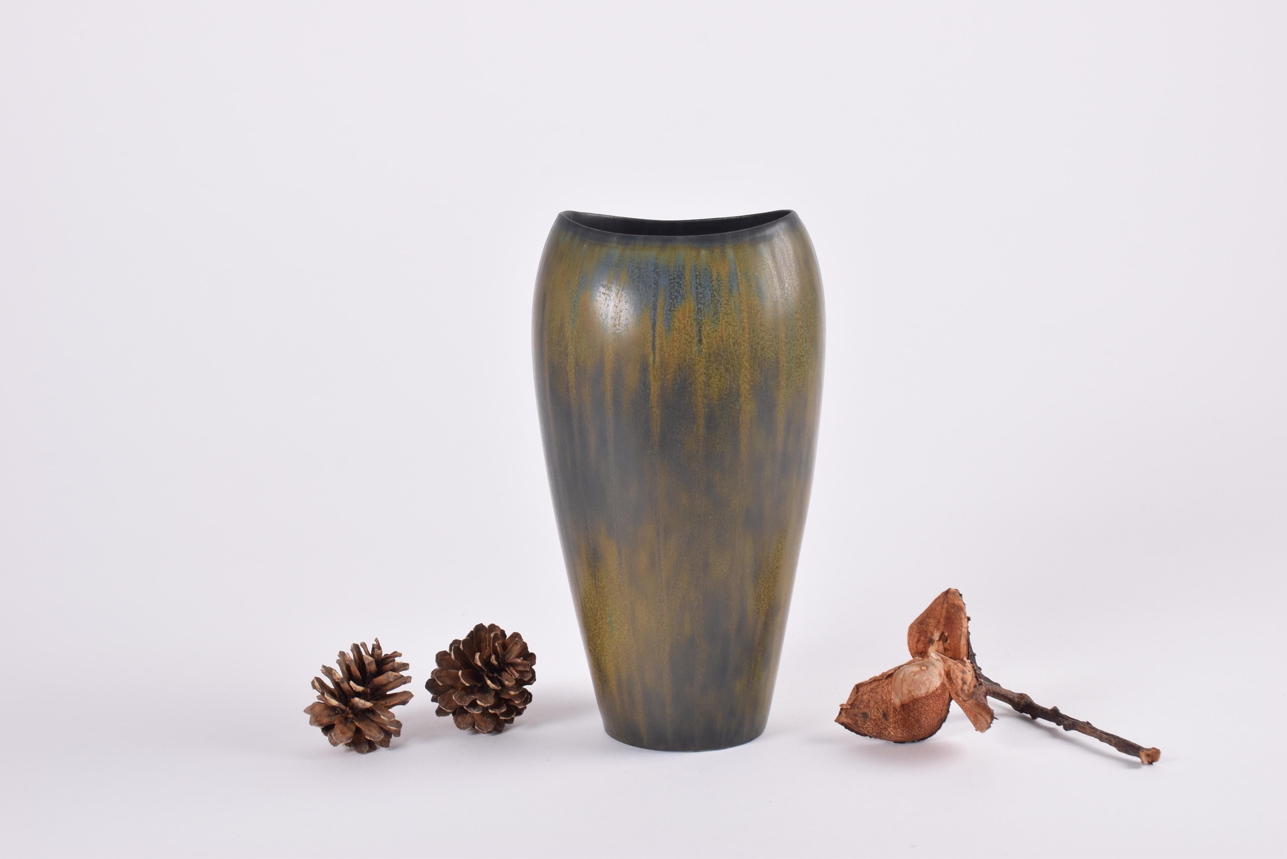 Absolutely stunning glaze on this vase by Gunnar Nylund for Rörstrand Sweden.
It's the model AXZ and it was designed and manufactured circa 1950s to 1960s.

The vase has an elegant shape with very thin lips towards the top. The glaze colors are