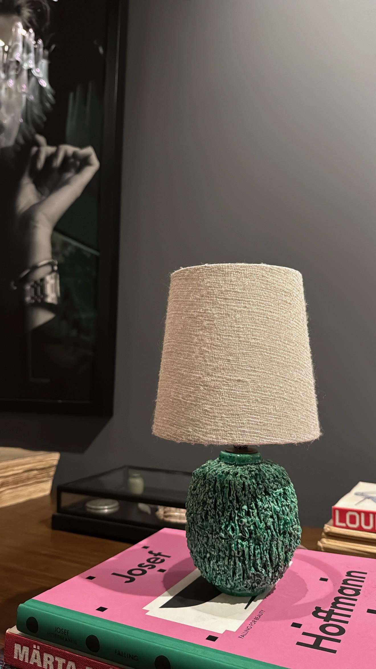 Scandinavian Modern Ceramic Chamotte Table Lamp in Green by Gunnar Nylund for Rörstrand, Sweden. The lamp was made in the 40's of chamotte clay and finished with a green colored luster glaze.
New lamp holder in brass. New EU wiring.

Excellent